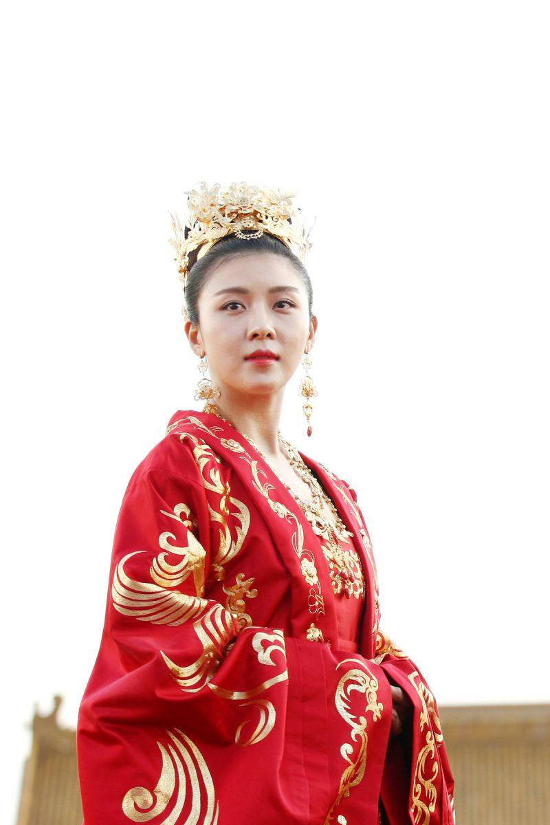身穿紅金傳統服飾、頭戴華麗冠冕的女性