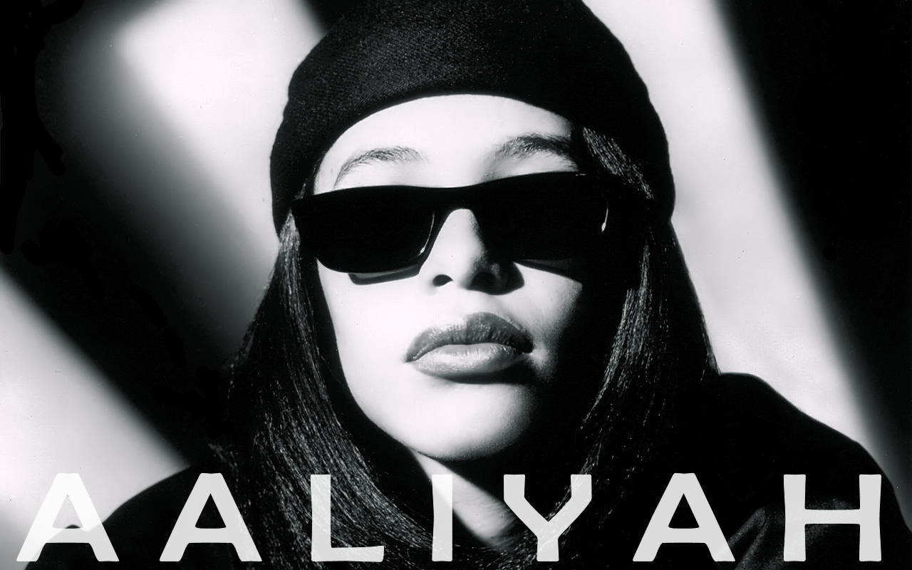 Aaliyah 戴著太陽眼鏡和冷帽，帶有粗體文字疊加。