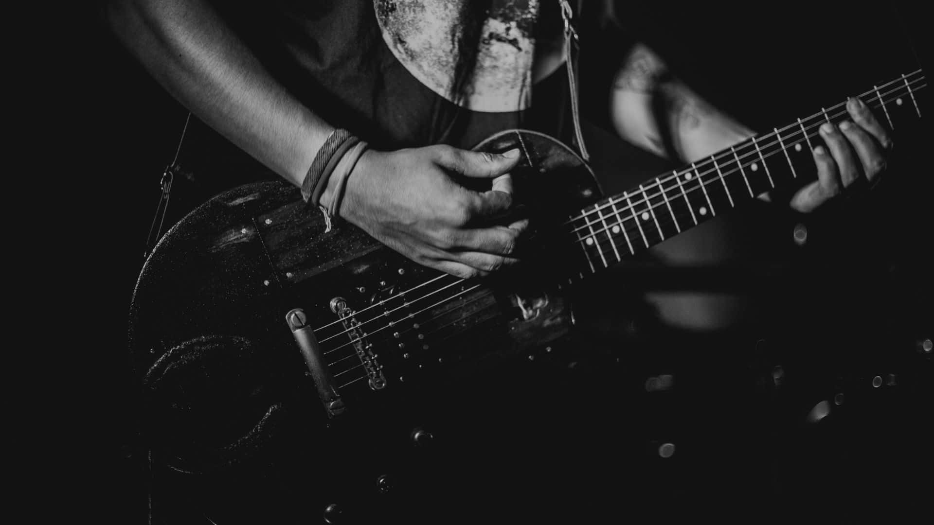 Black And White Guitar 桌布 壁紙 — 音樂家的雙手在單色戲劇性舞台燈光下熟練地彈奏黑色電結他。