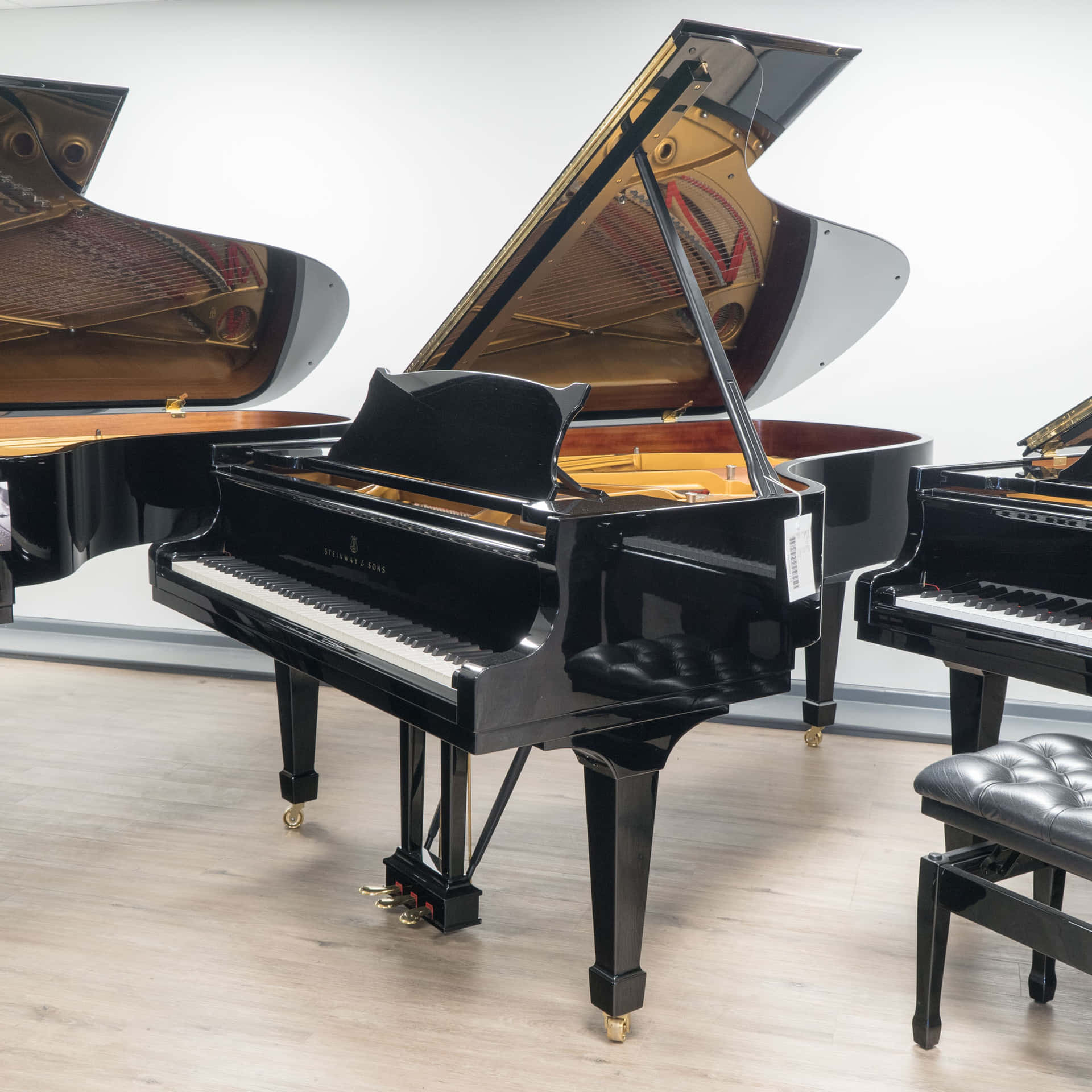 現代展廳中三塊打開琴蓋的黑色三角鋼琴。