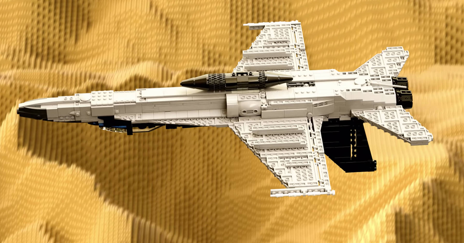 白色LEGO戰鬥機模型在帶有紋理的金黃色LEGO背景上。