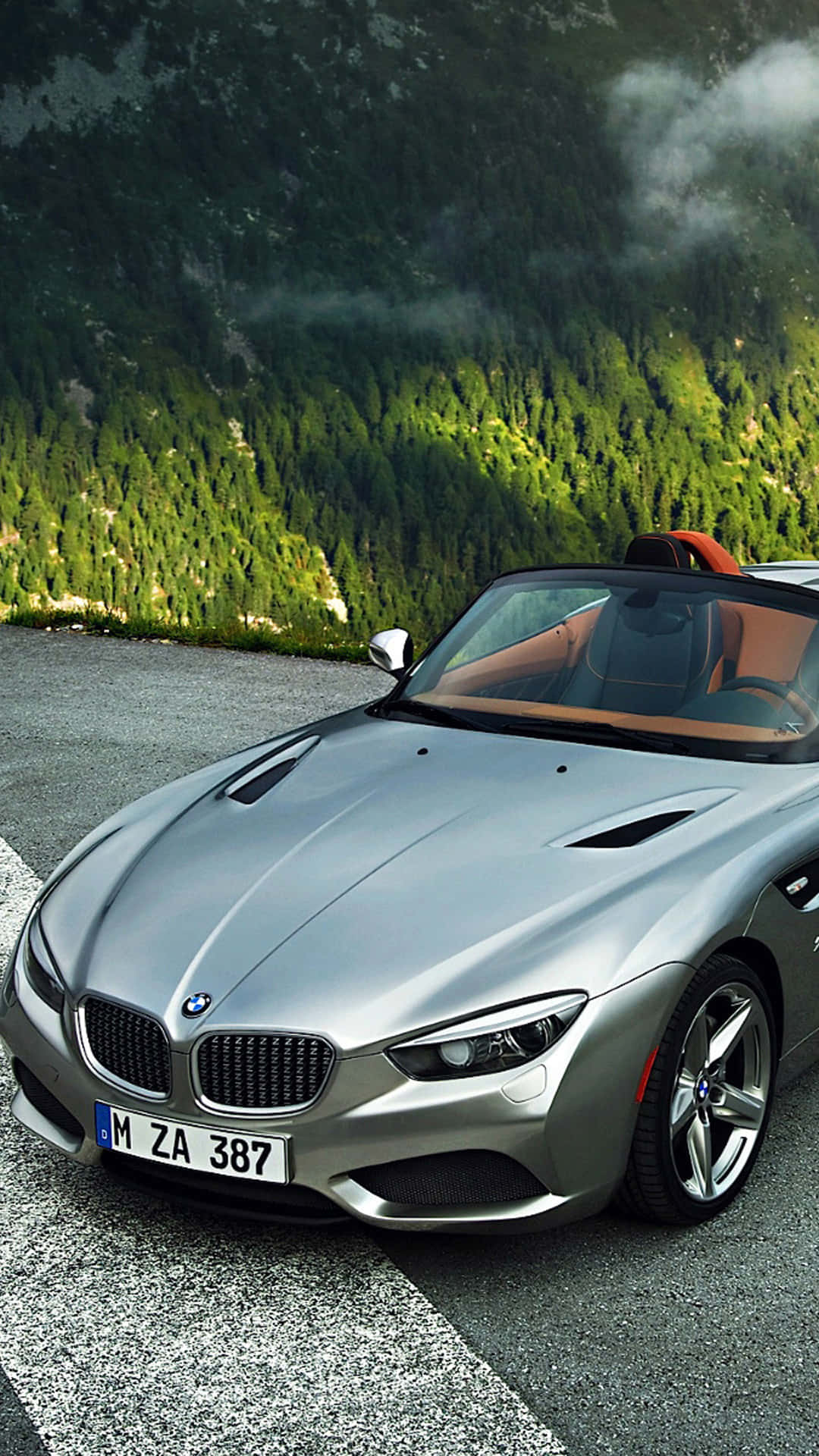 銀色BMW Z8開篷跑車停泊在山路上，有森林和霧氣山峰。