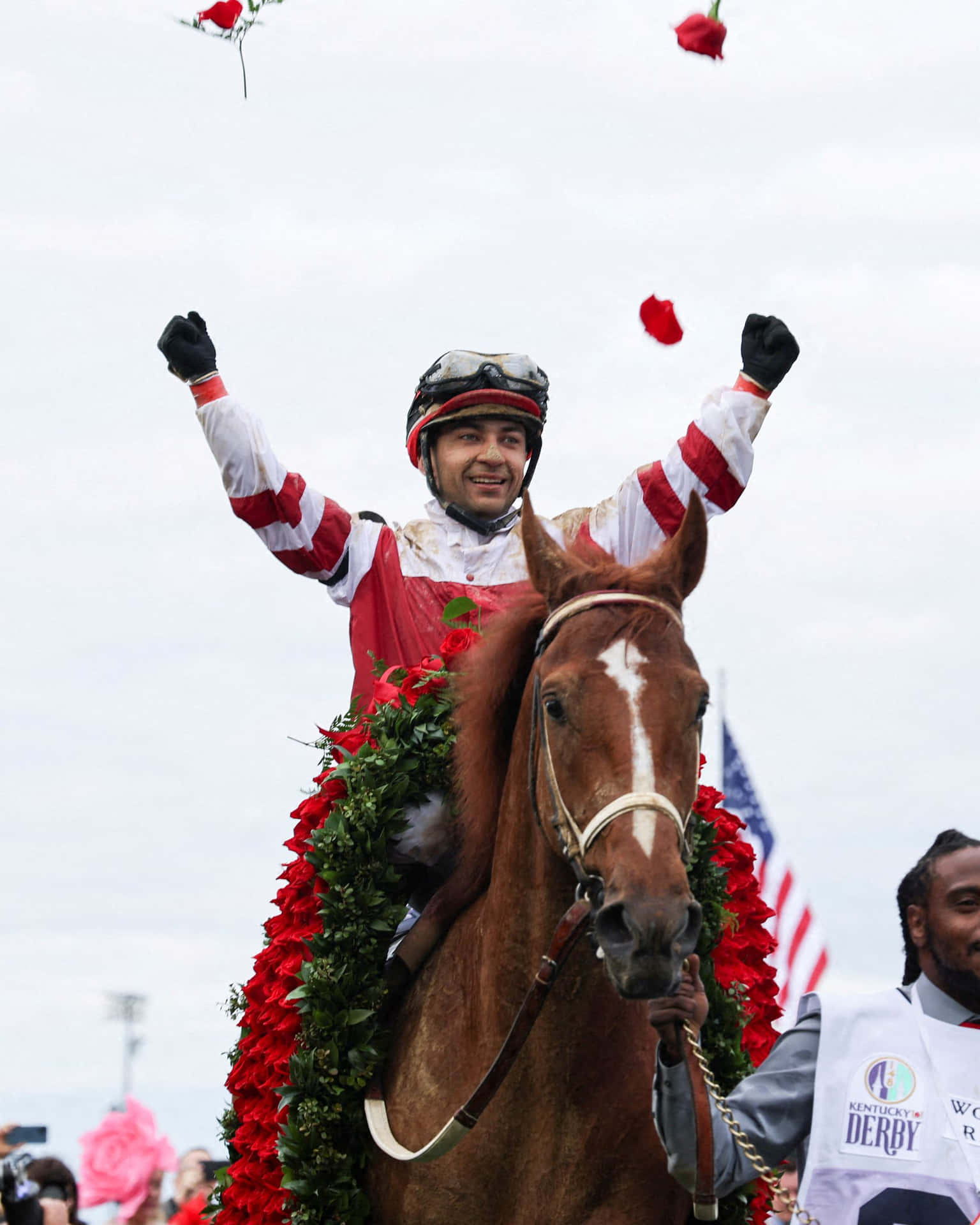 騎師在肯塔基打吡大賽中騎著飾有紅玫瑰的馬匹慶祝勝利。