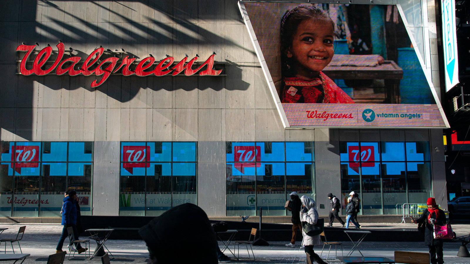 Walgreens 商店，帶有大型小孩廣告牌和走過的行人。