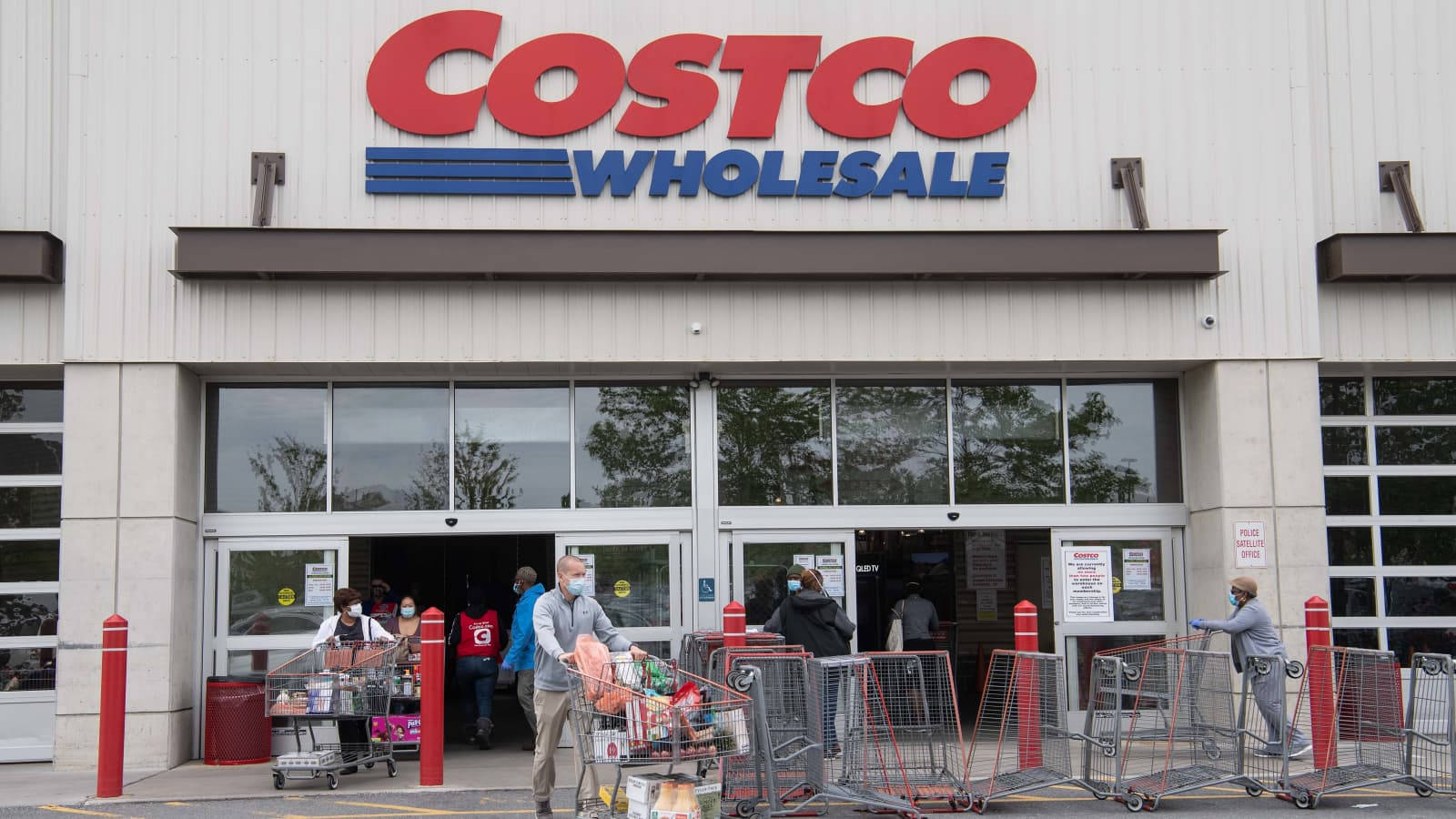 戴著口罩的購物者推著滿載的購物車離開 Costco。