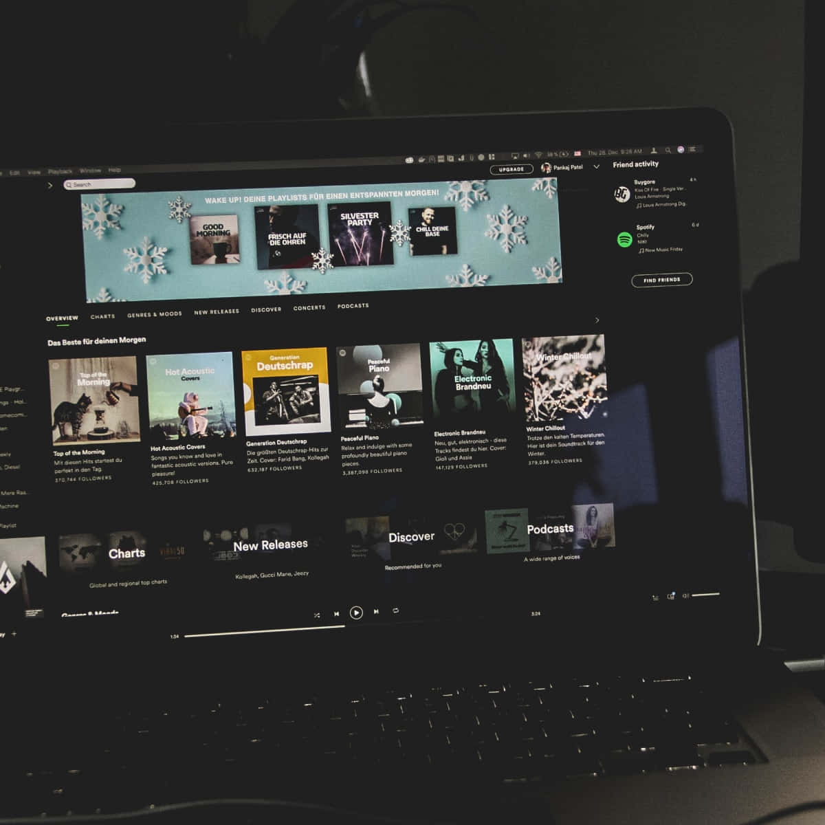 手提電腦屏幕顯示 Spotify 音樂應用程式，帶有冬季播放清單和雪花圖案。