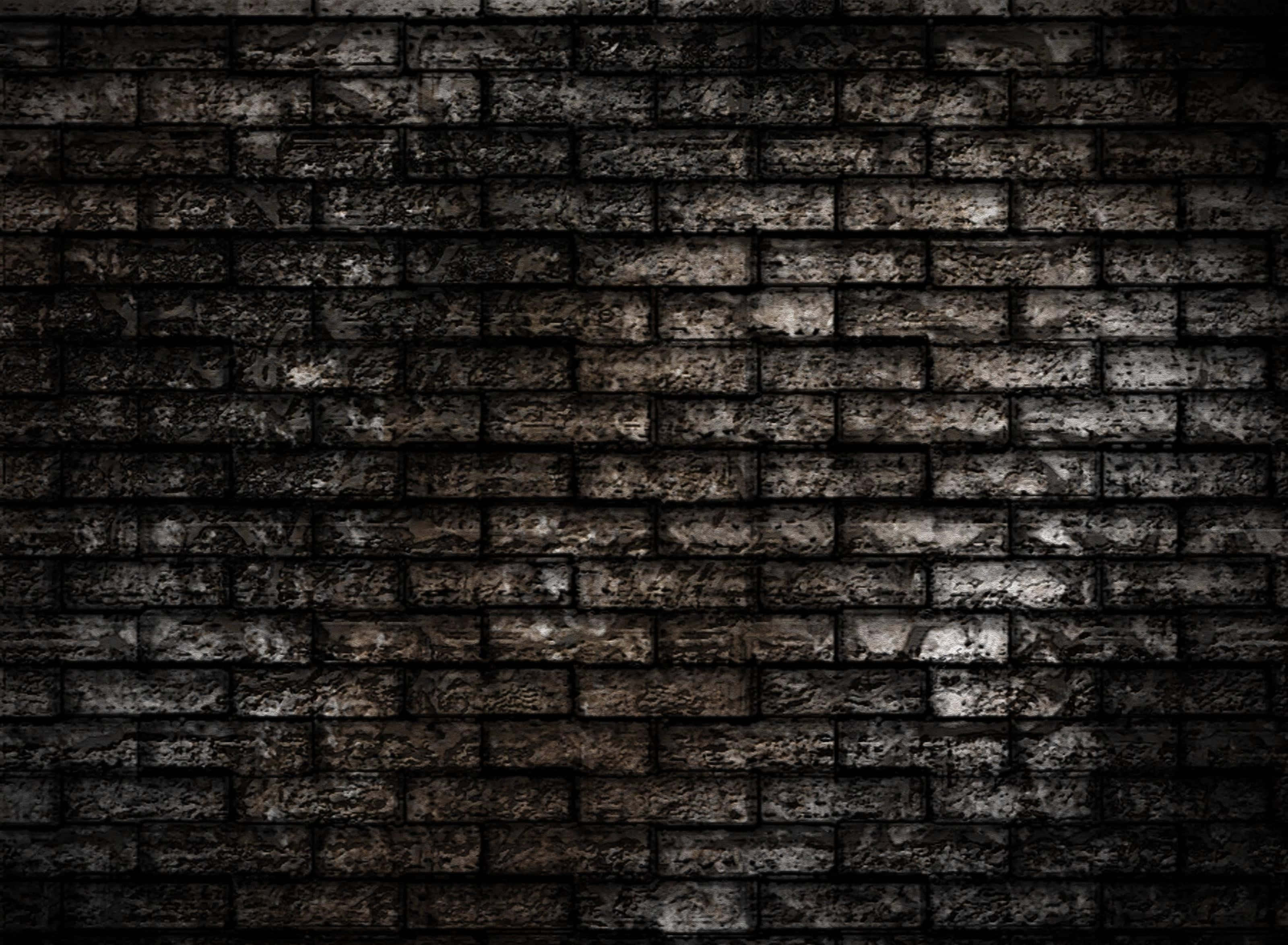 Dark Wall 桌布 壁紙 — 風化磚牆的特寫，帶有深色污垢和微妙的光線亮點，營造出粗糙的城市質感。