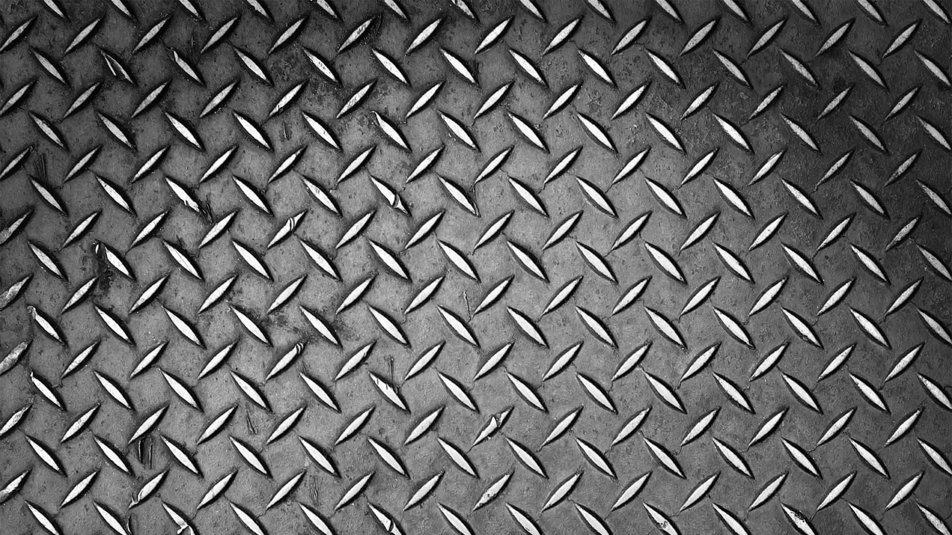 Diamond Plate 桌布 壁紙 — 風化鑽石紋金屬表面的特寫，帶有紋理脊線和微妙的灰色銅鏽。