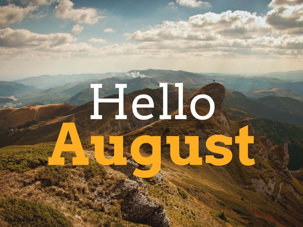 August 桌布 壁紙 — 風景優美的山景，有連綿起伏的山丘和山峰上的十字架，天空部分多雲，並帶有粗體「你好八月」文字疊加。