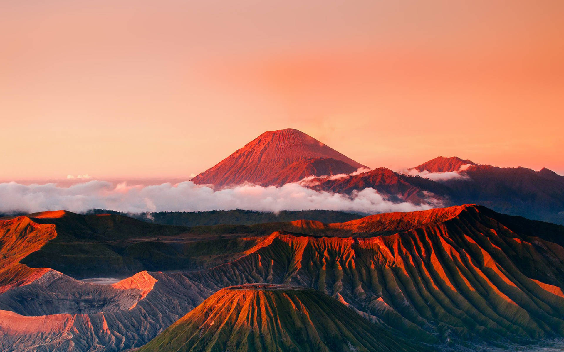 日出在火山山脈上，雲在下方