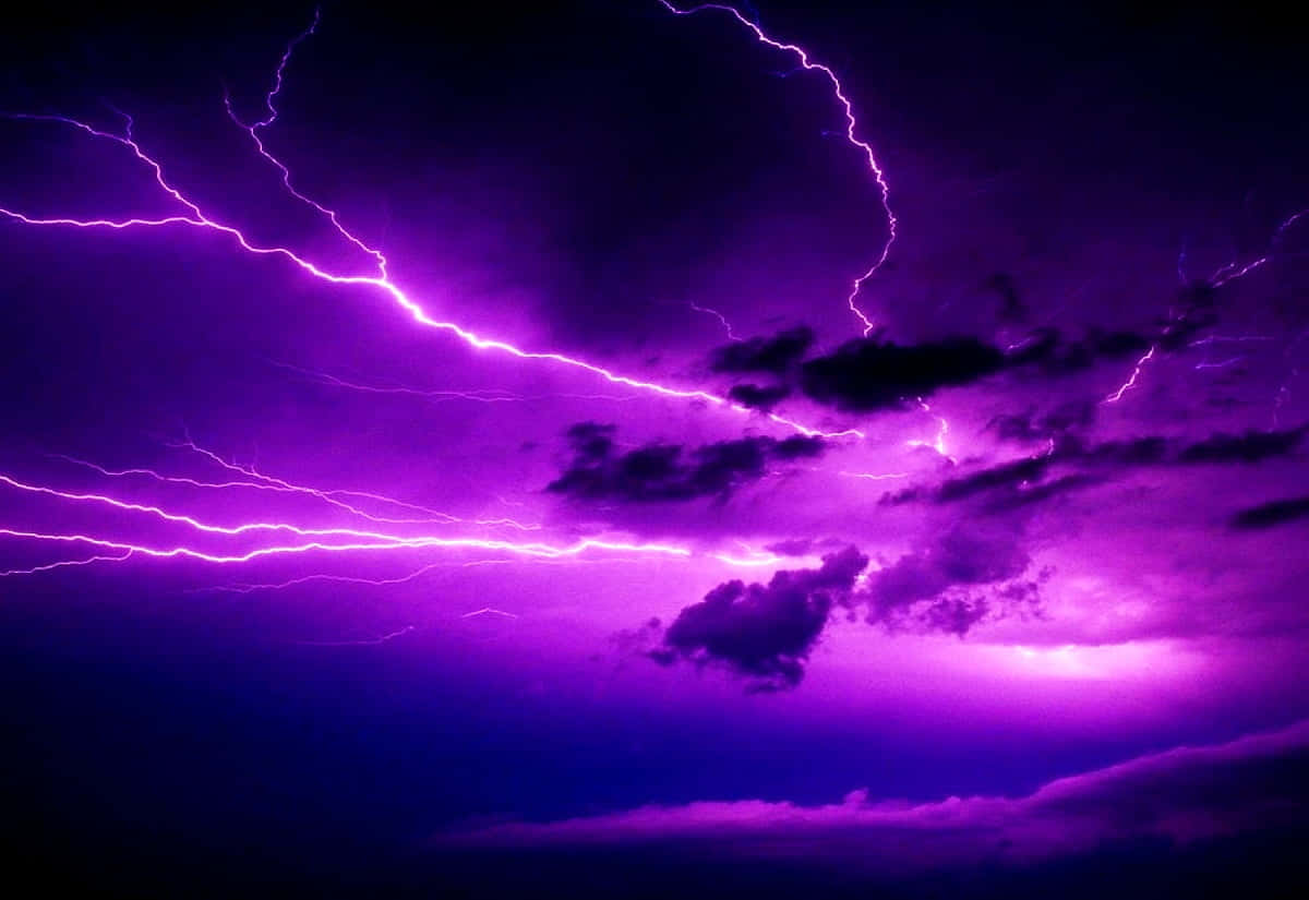 風暴之眼 壁紙 — 生動的紫色閃電在暴風雨的天空中分叉，照亮了烏雲，形成戲劇性的電光展示。