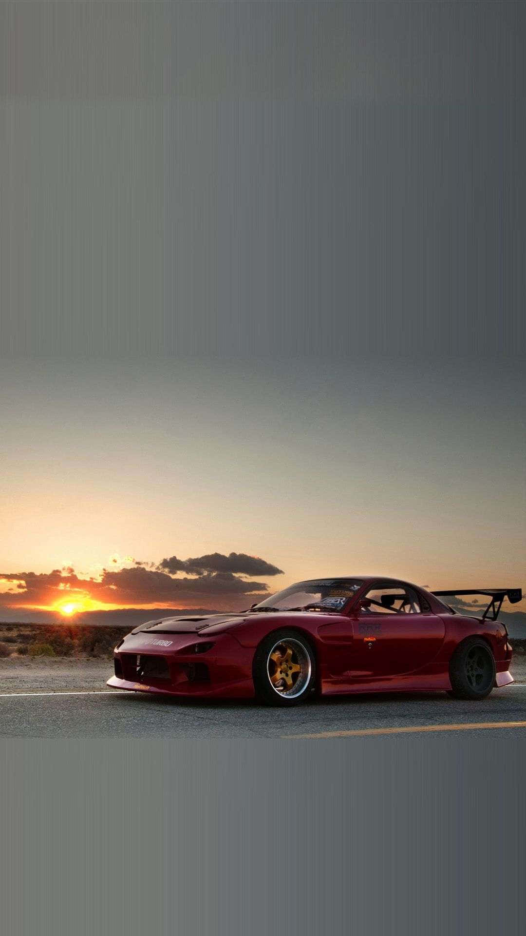 紅色跑車停在沙漠公路上，夕陽西下，橙色天空。