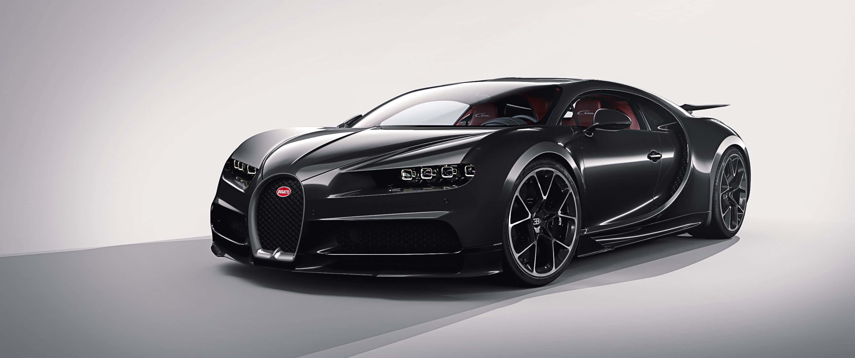 風馳電掣，盡顯尊貴 壁紙 — 一輛時尚的啞光黑色Bugatti Chiron跑車，配備紅色內飾和黑色輪轂，在極簡工作室環境中展示。