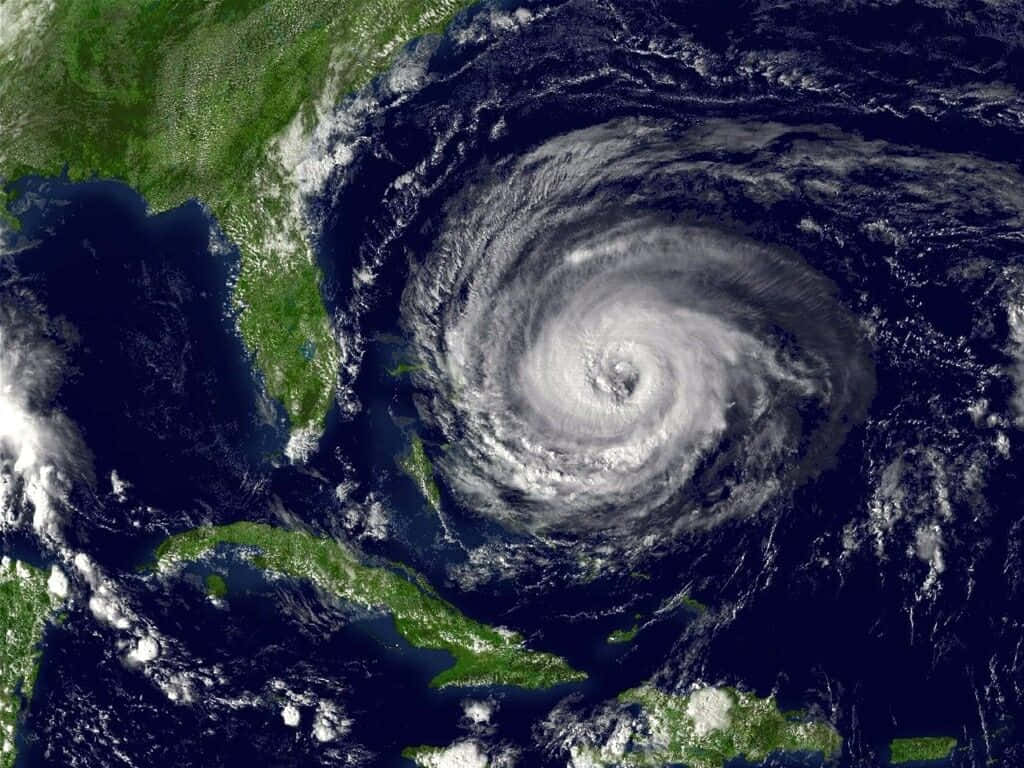 颶風的兇猛不可低估 壁紙 — 一個巨大的颶風在大西洋上空旋轉，帶有清晰的風眼，正接近加勒比海島嶼和美國東南部。