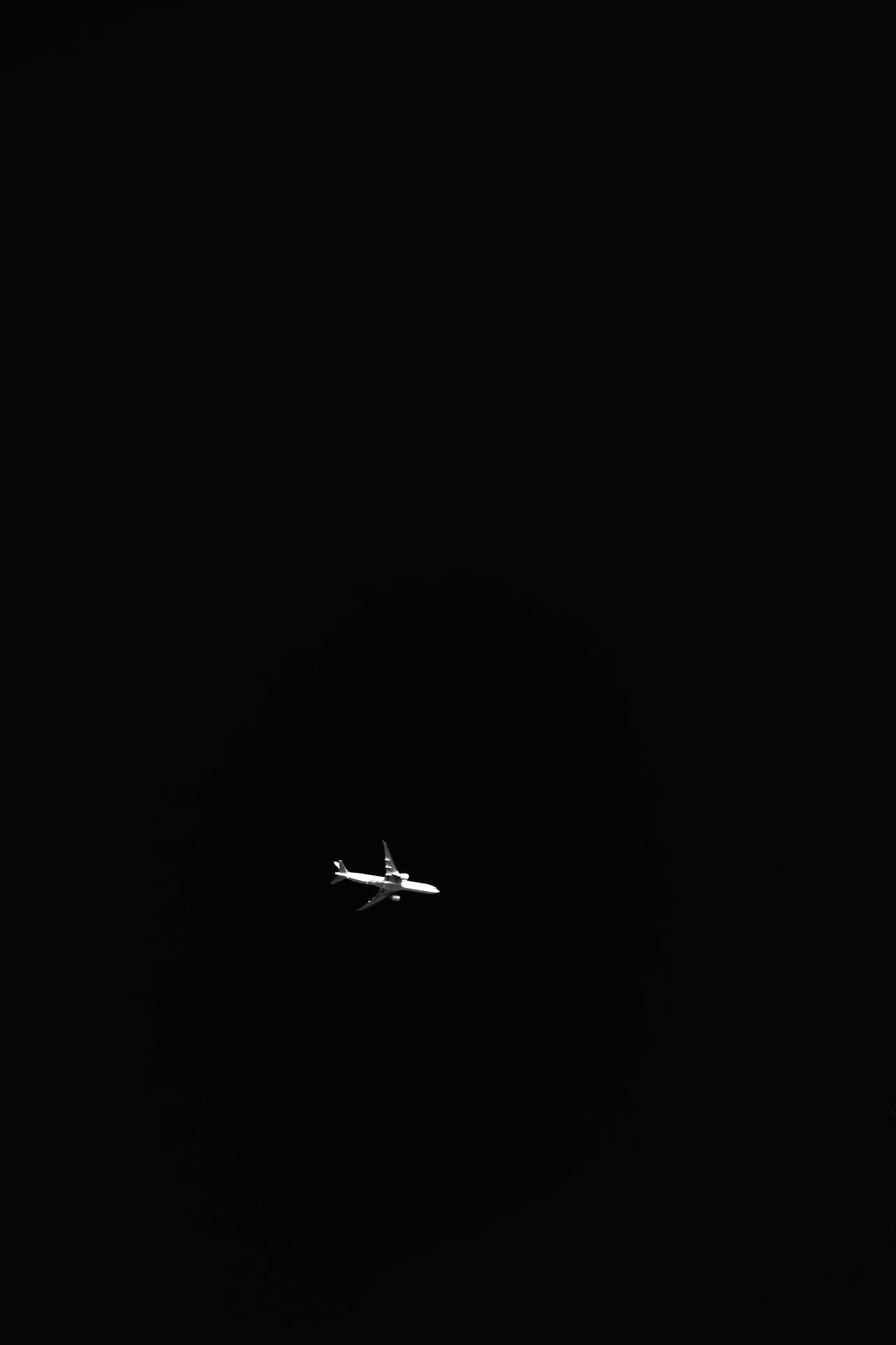 一架飛機獨自在黑暗的夜空中飛行。