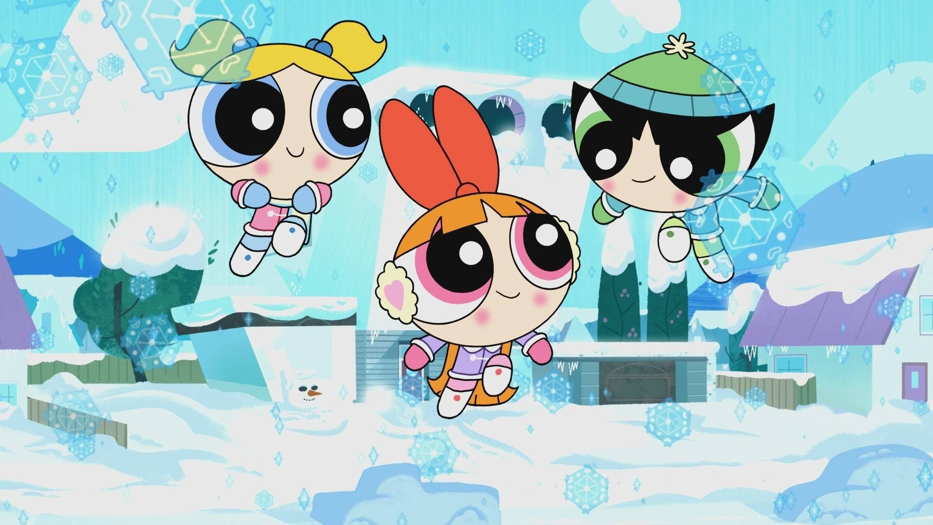 《飛天小女警》雪天場景 壁紙 — 三個穿著冬季裝備的卡通女孩在雪花飄落和冰凍屋頂的雪村上空快樂地漂浮。