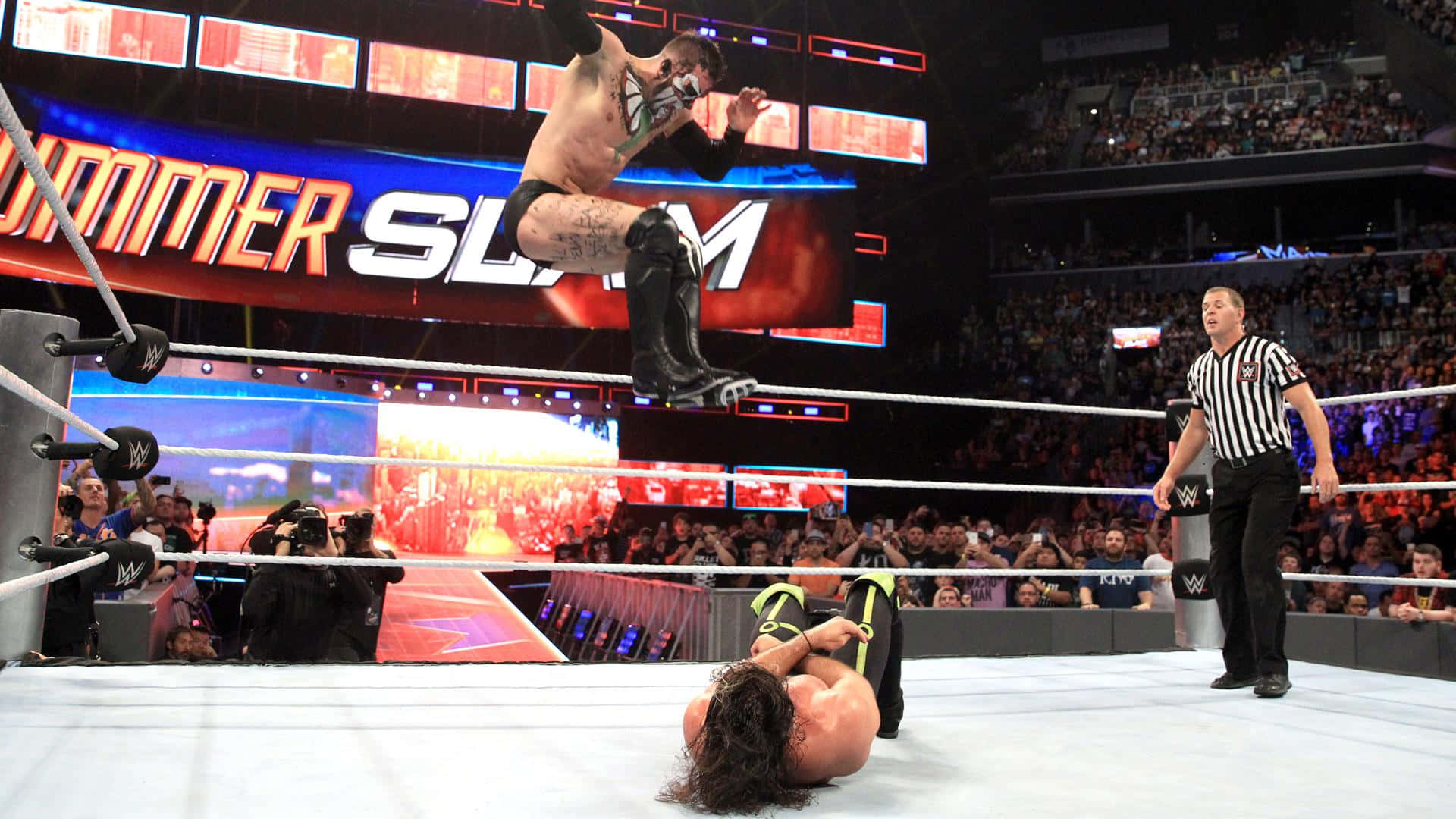飛天戰士芬·巴洛 壁紙 — 在WWE SummerSlam賽事中，一名摔角手從頂繩跳向一名俯臥在擂台上的對手。