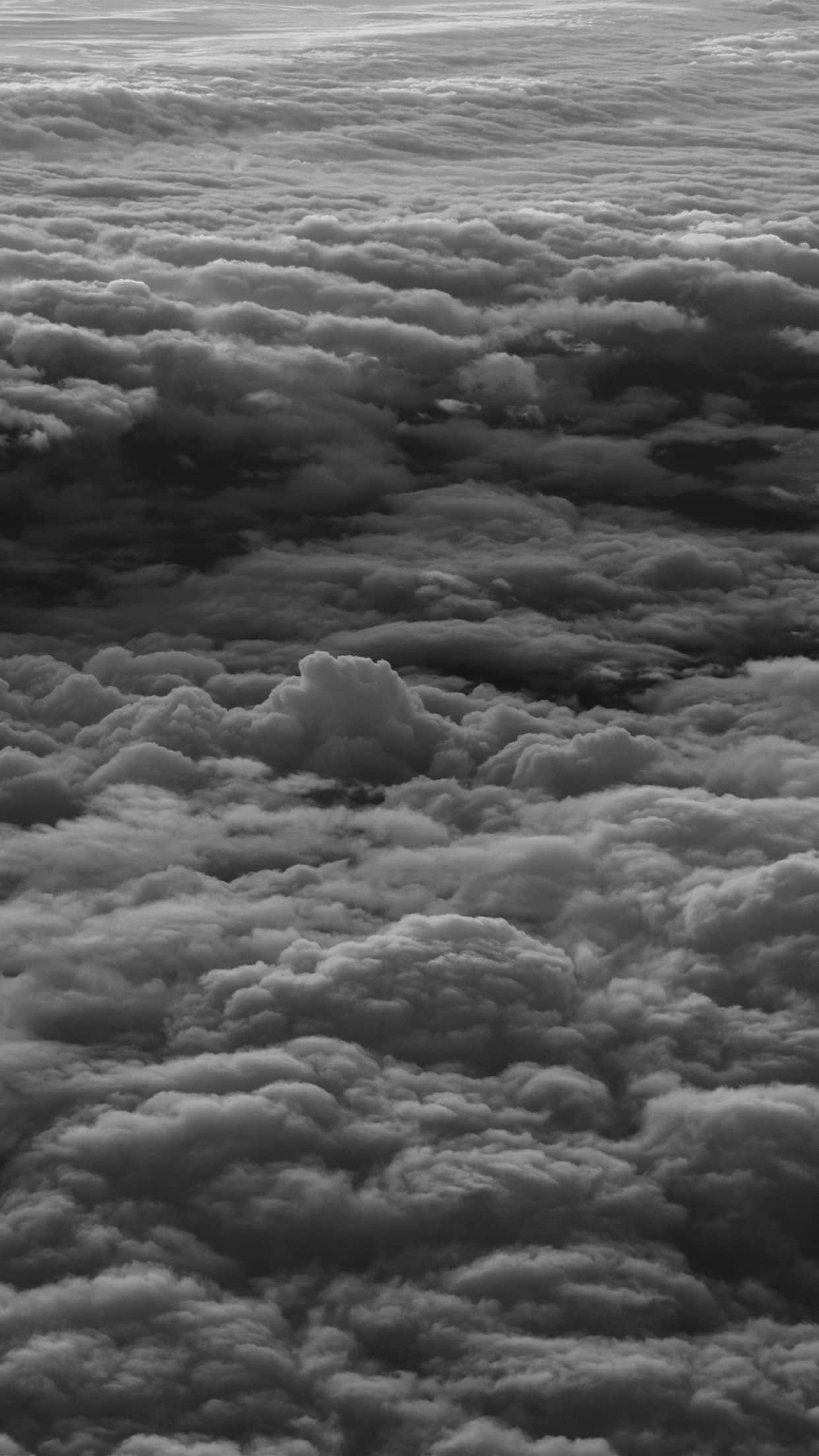 Black And White Sky 桌布 壁紙 — 飛機下方延伸的無盡紋理雲海的航拍黑白視圖。