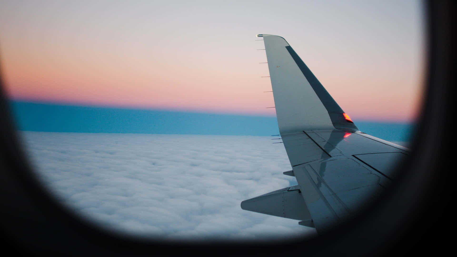 夕陽時從窗戶看到的雲上飛機機翼