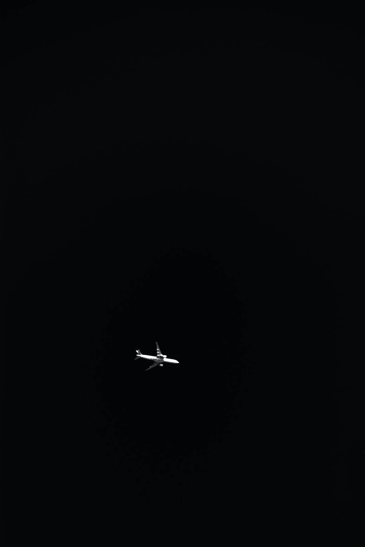 一架飛機獨自在黑暗的夜空中飛行。