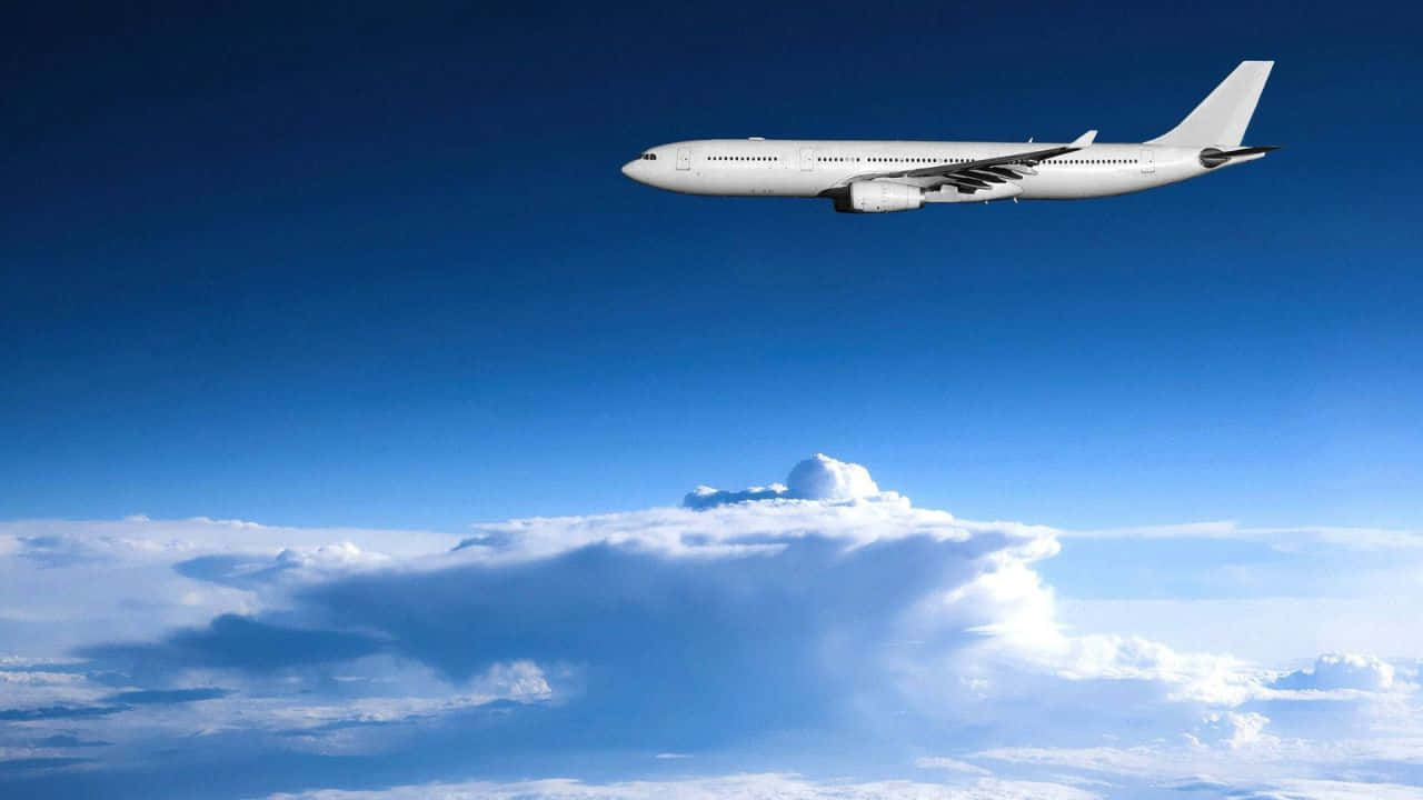 「飛機穿雲而過，720p畫質」 壁紙 — 一架流線型白色客機在湛藍天空襯托下翱翔於蓬鬆白雲之上。