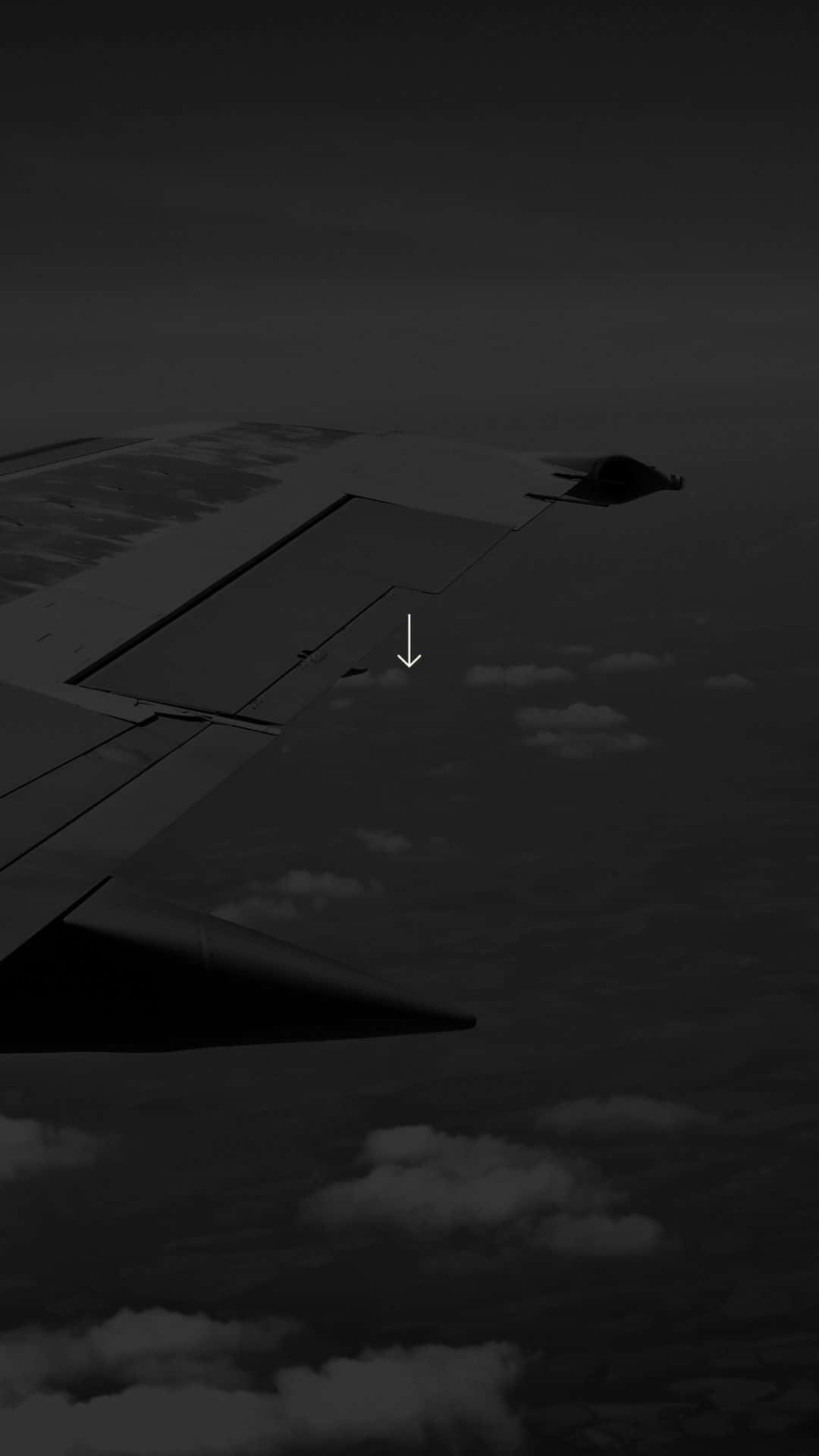 飛機機翼在雲層上方飛行，帶有向下箭頭