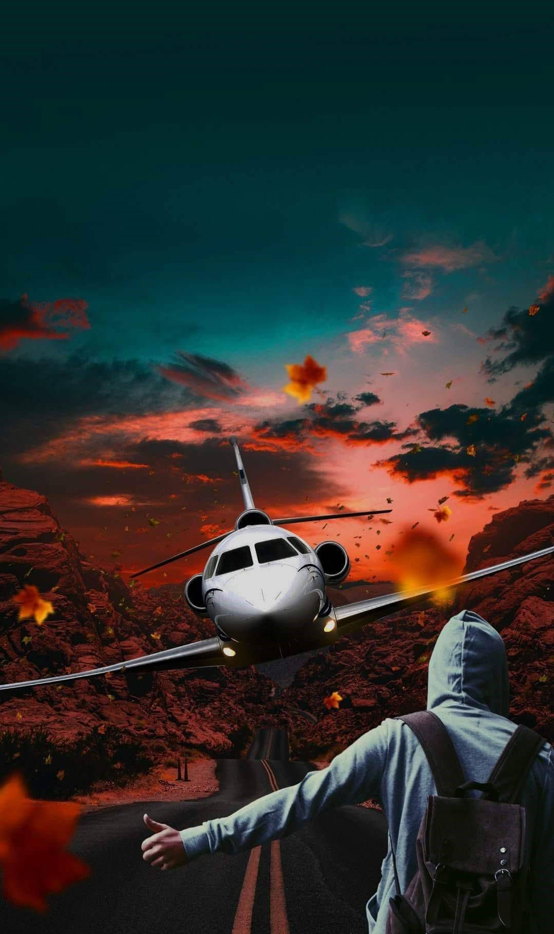 飛機與男子藝術畫 壁紙 — 一個孤獨的旅行者穿著連帽衫，伸手朝向在日落峽谷上空翱翔的私人飛機，熾熱的橙色樹葉在空中旋轉。
