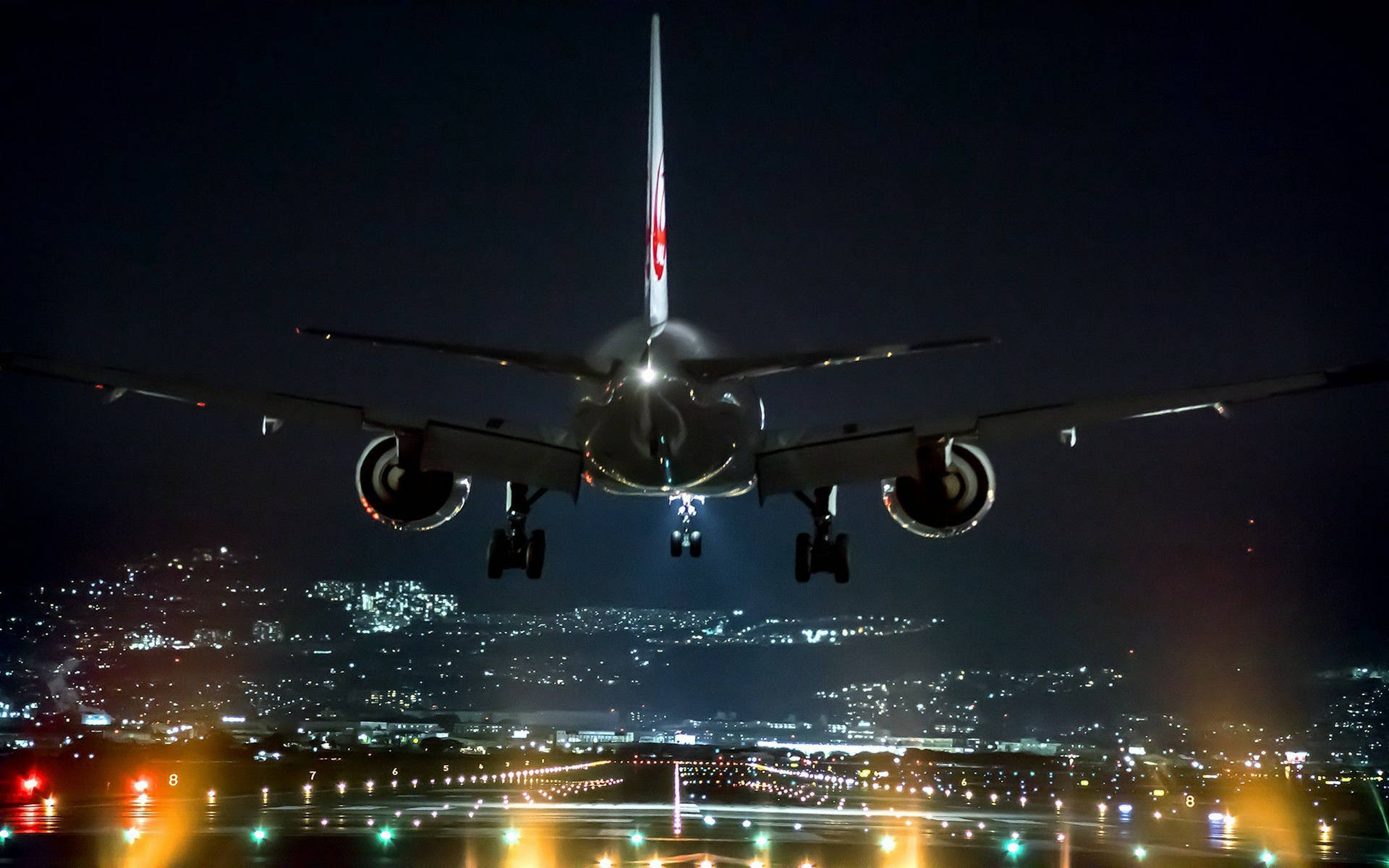 夜間飛機在下方城市燈光中降落