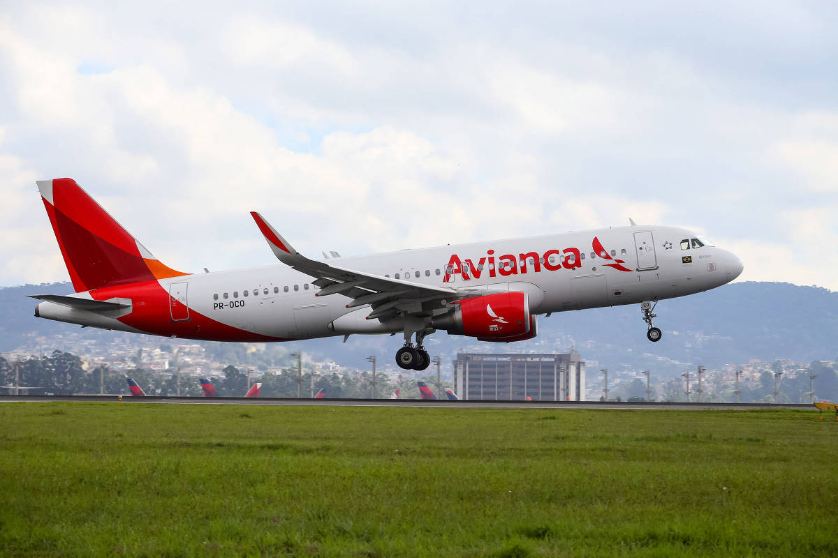 Avianca飛機在綠草和山丘背景下從跑道起飛。
