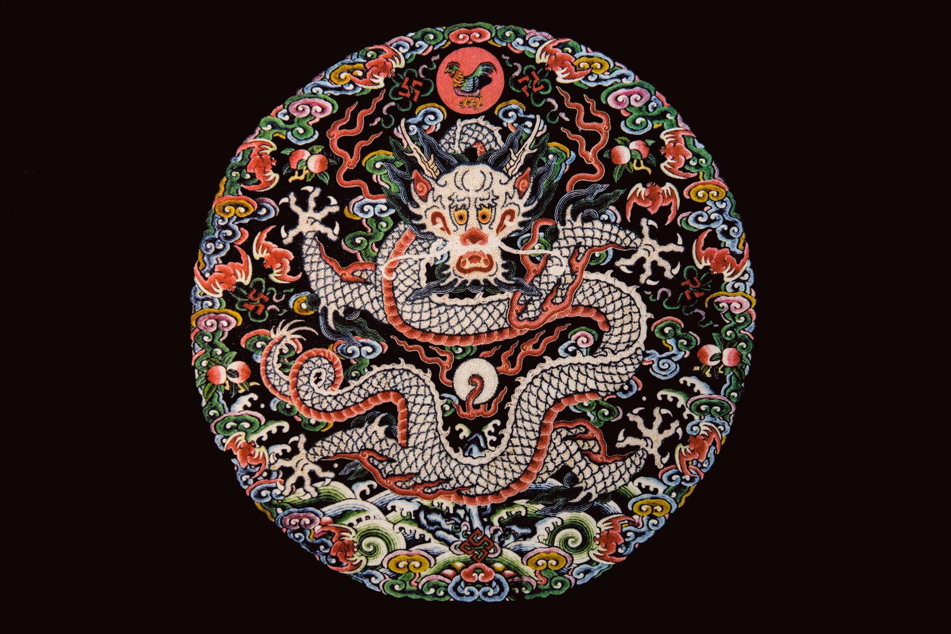 飛越山脈的神龍 壁紙 — 一個充滿活力的圓形刺繡，上面有一條細節豐富的白龍纏繞在色彩繽紛的漩渦圖案和神話生物之間，背景為深色。