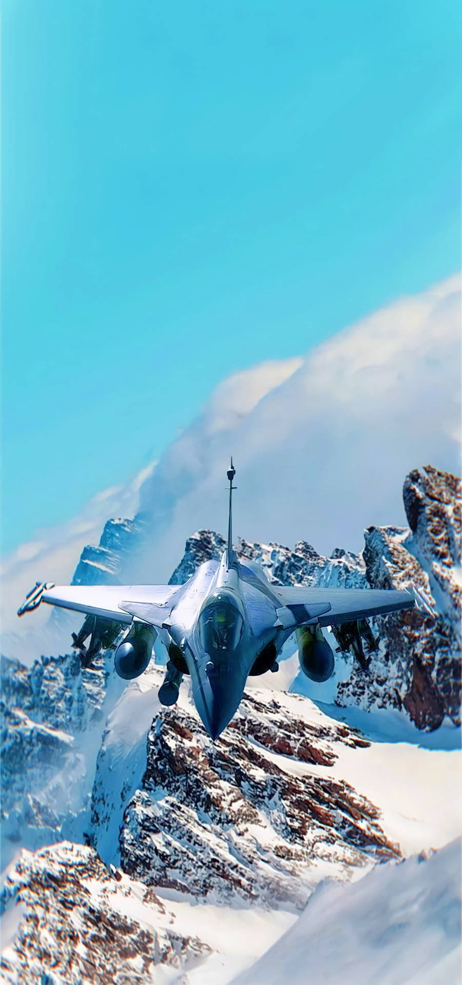 戰鬥機在藍天下低空飛越積雪的山峰