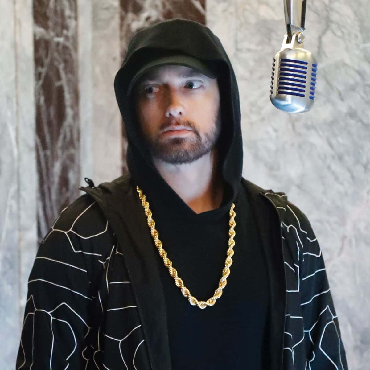 Eminem 桌布 壁紙 — 饒舌歌手Eminem在錄音室裡專注地凝視，身旁掛著一個復古銀色麥克風。