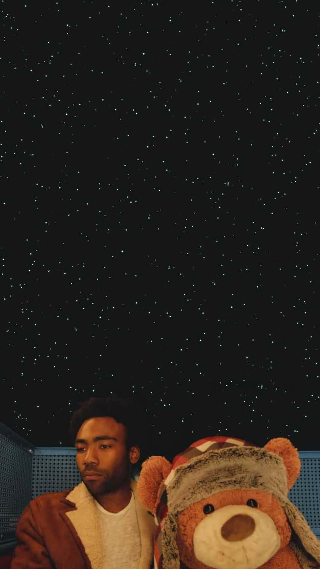 一個年輕人和一隻泰迪熊仰望星空。
