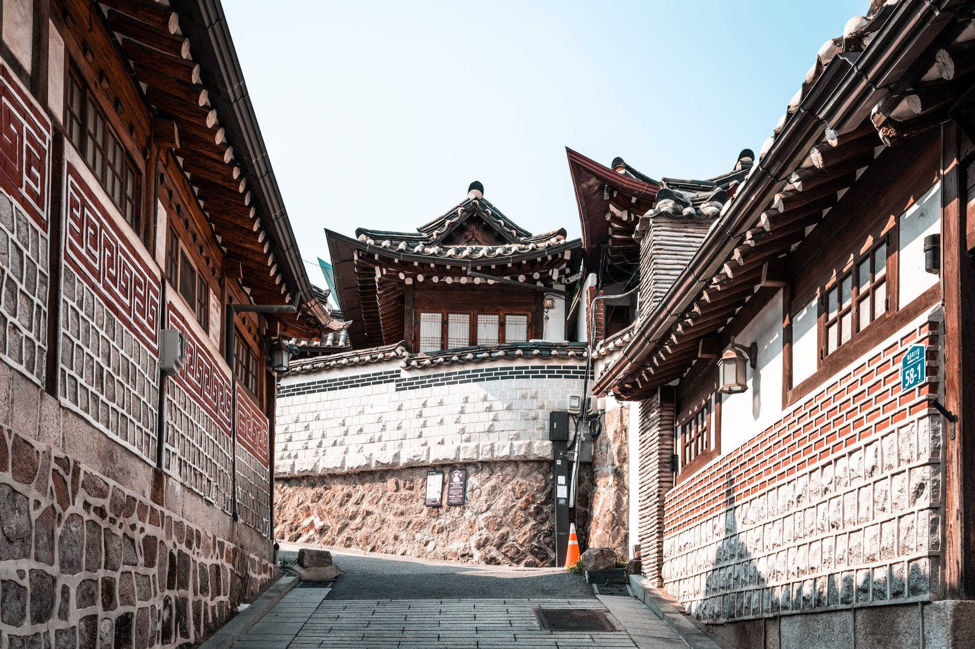 傳統韓國小巷，有石頭和木頭建築，在明亮的藍天下。