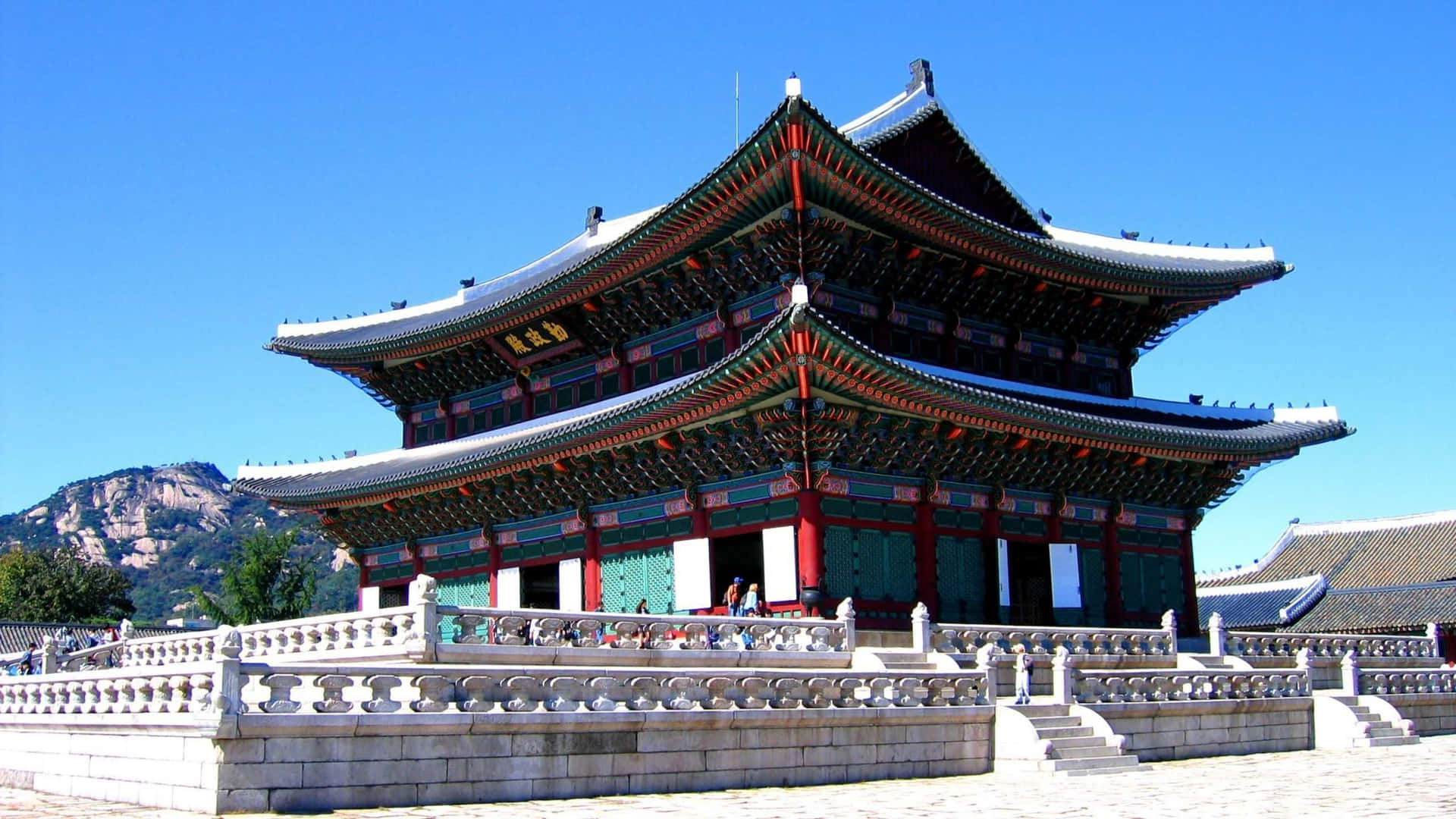 韓國宮殿，曲線屋頂和石欄杆，在明亮的藍天下