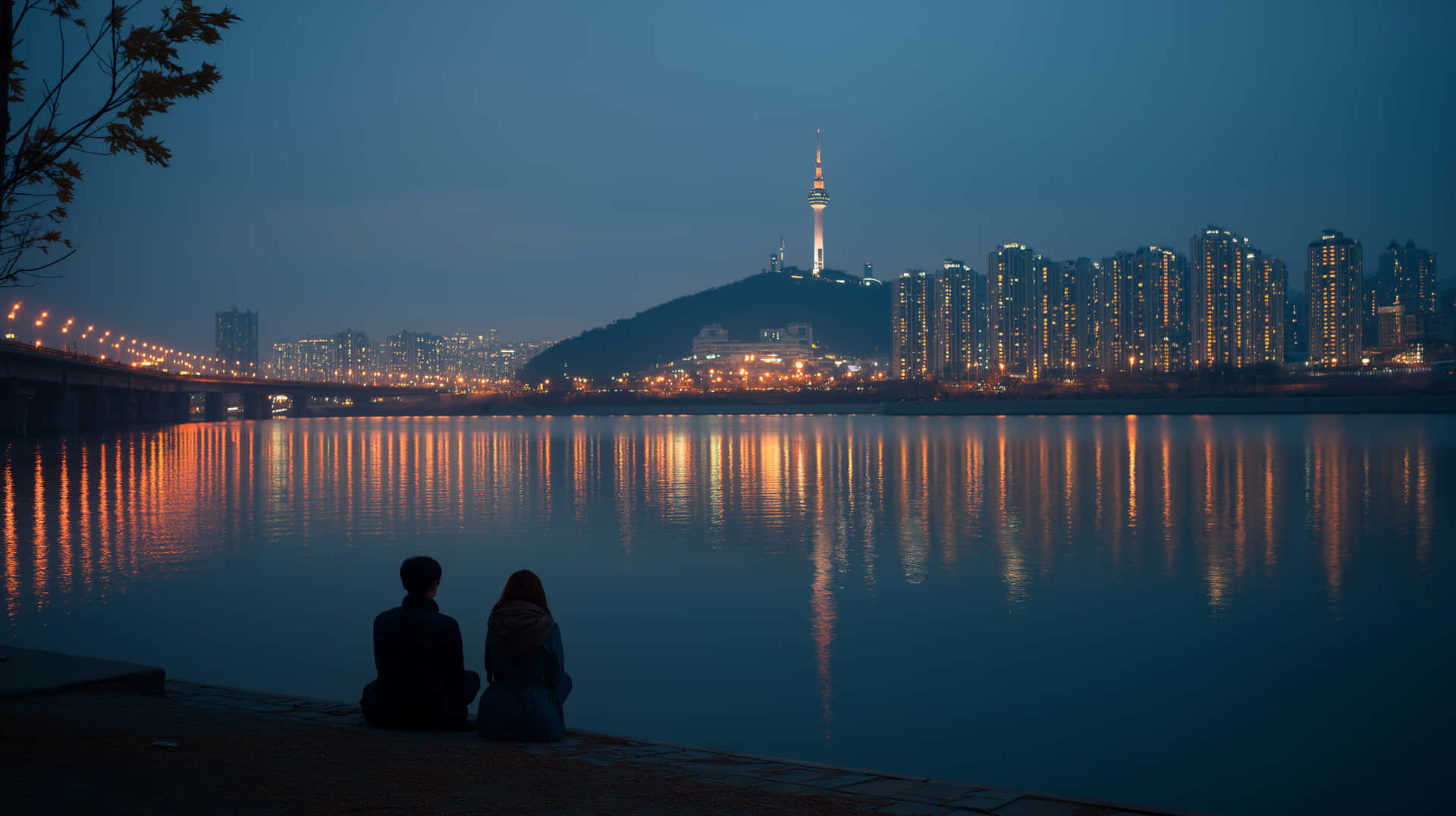 兩個人晚上坐在河邊，觀看城市燈光在水面上反射，山上有座塔樓。
