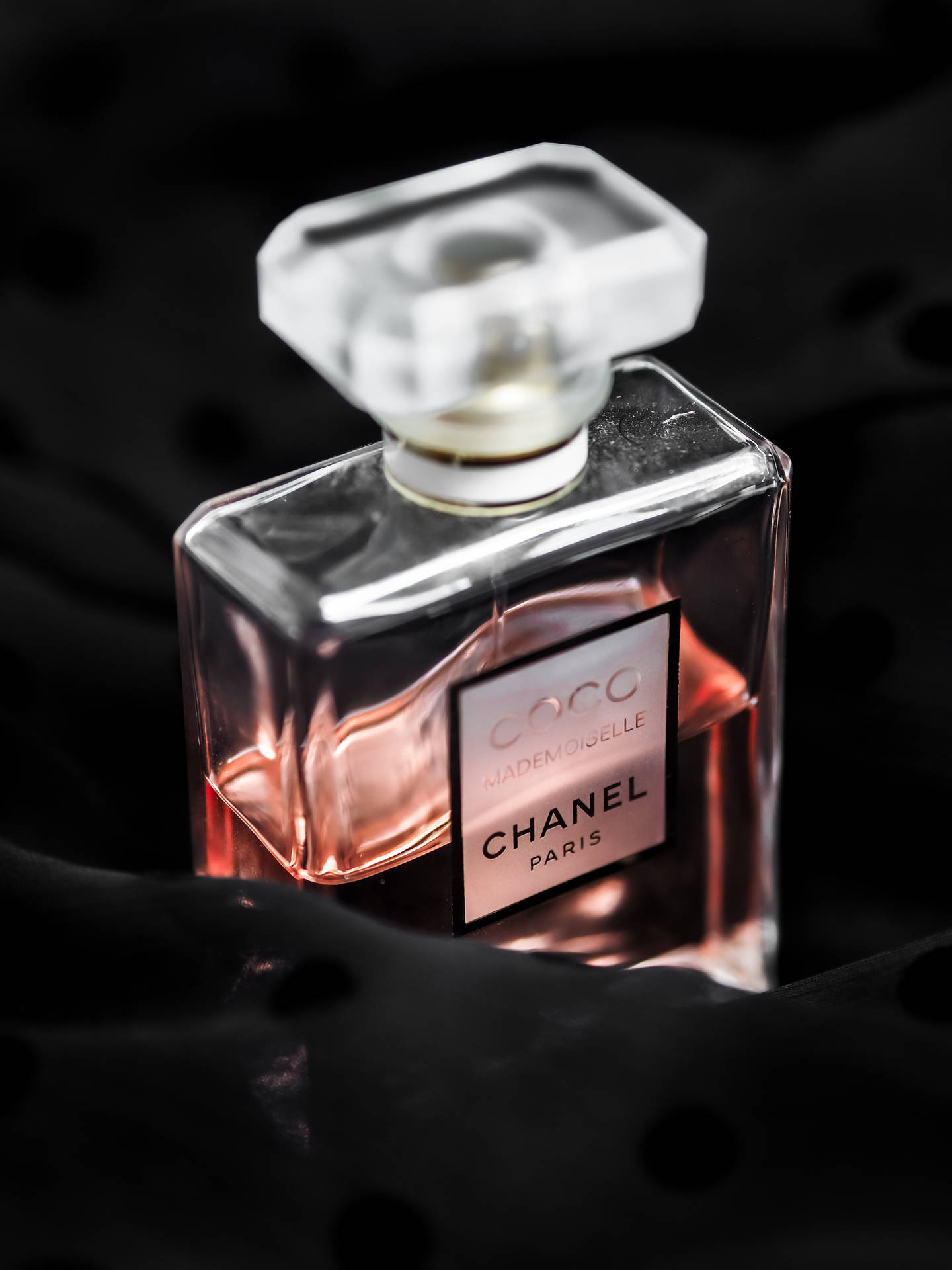 黑色布料上的 Chanel Coco Mademoiselle 香水瓶