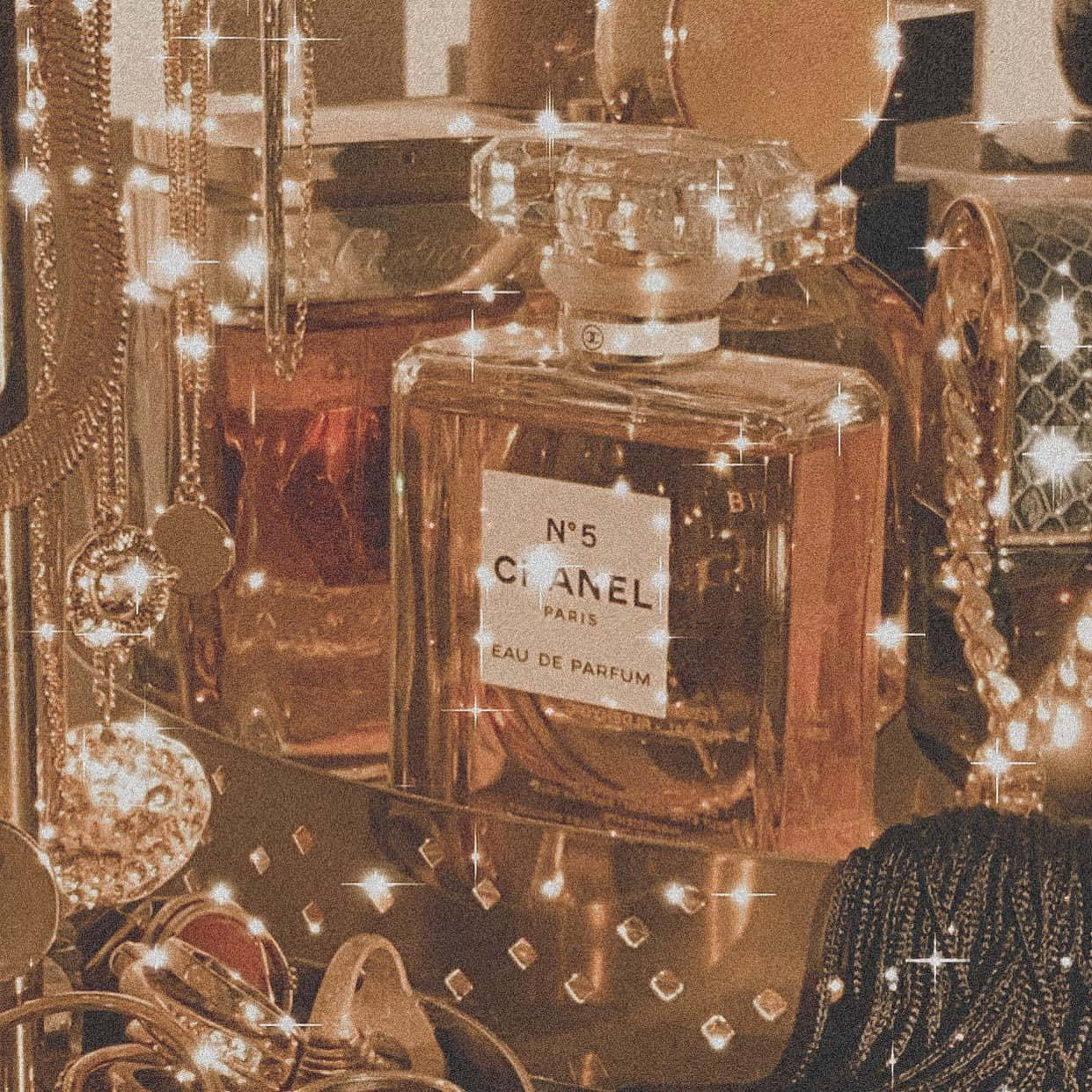 香奈兒新系列的優雅風範 壁紙 — 復古Chanel No 5香水瓶在奢華珠寶和金色配飾中閃爍著光芒。