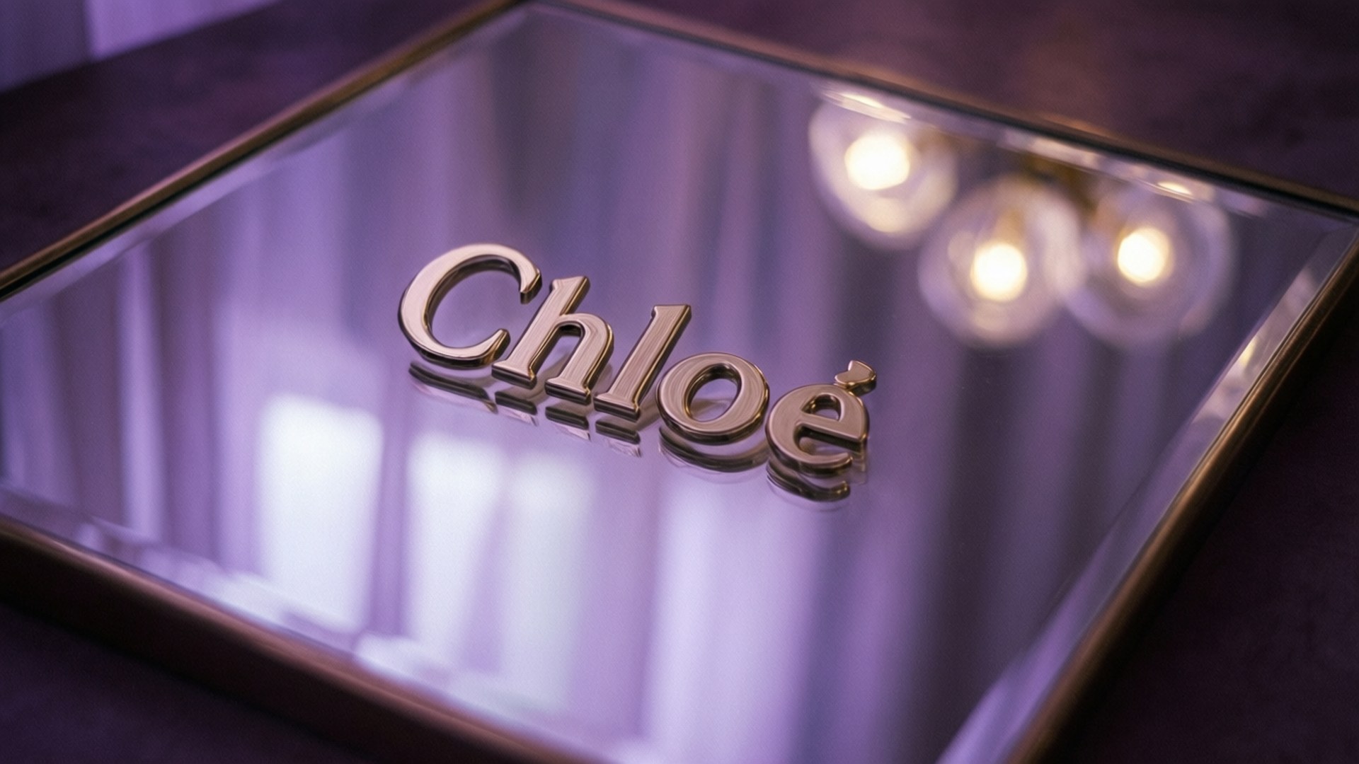 鏡面上的金色 Chloe 標誌，柔和紫色燈光，背後模糊燈光。
