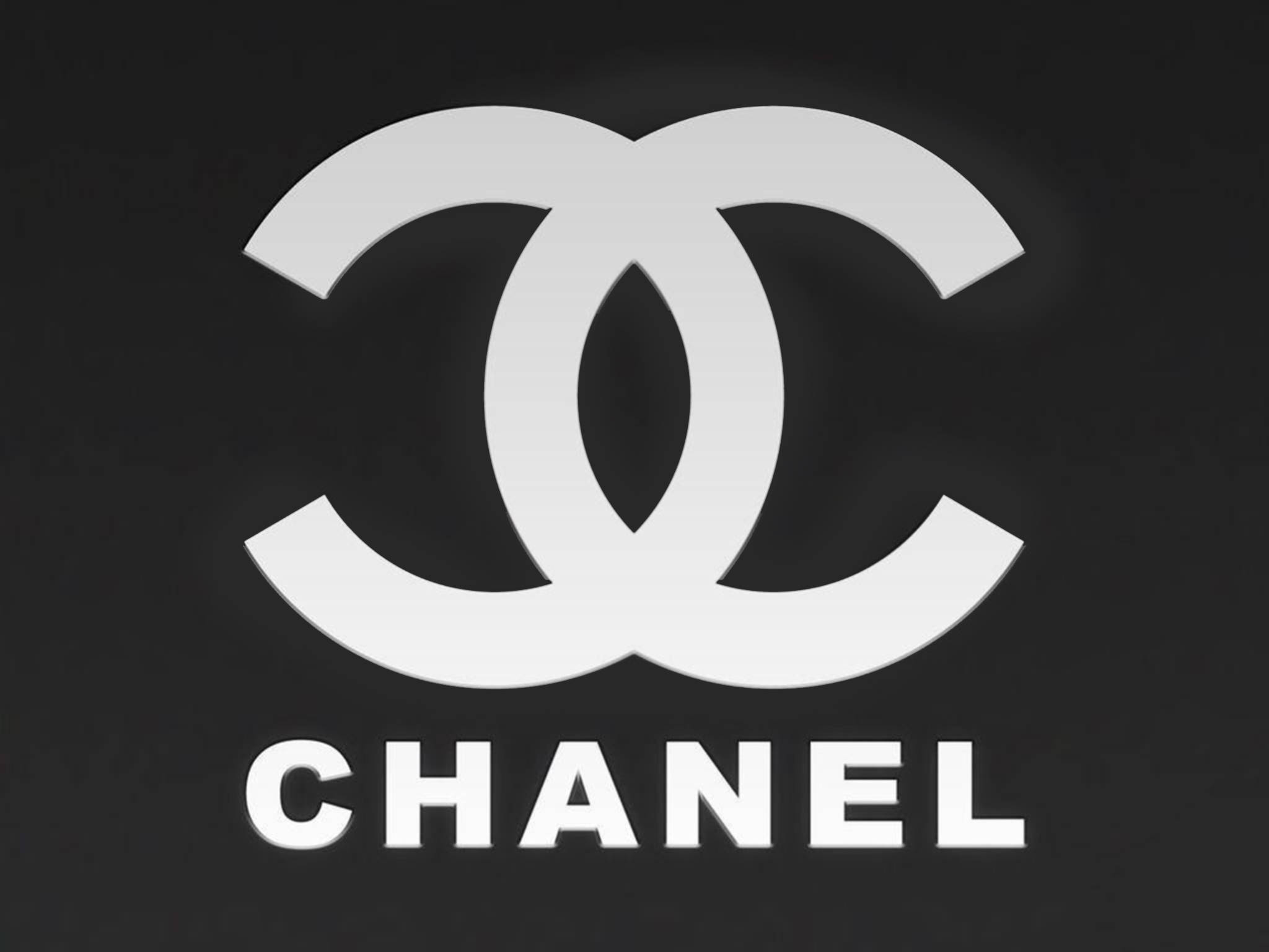 香奈兒標誌黑底版 壁紙 — 標誌性的白色Chanel標誌，帶有交織的C和品牌名稱，在純黑色背景上格外突出。