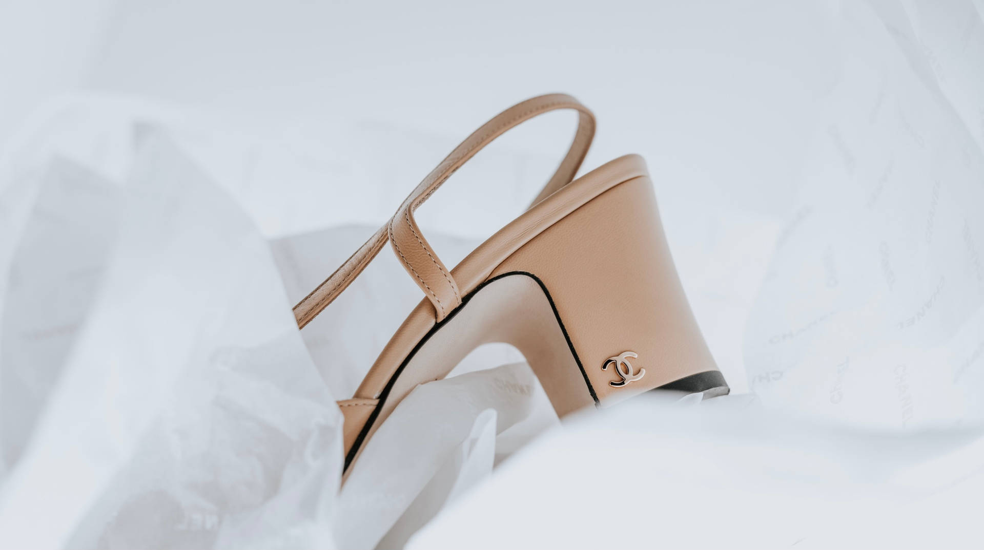 白色紙巾上的米色 Chanel 露跟高跟鞋