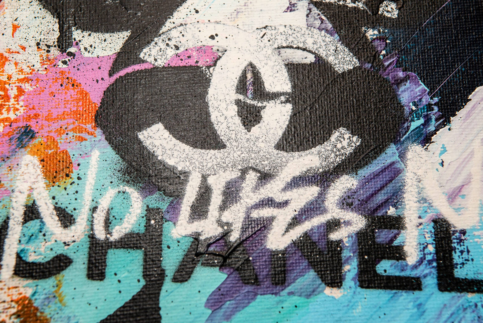 在紋理畫布上的塗鴉藝術，帶有 Chanel 標誌和文字「No Lives In Chanel」。