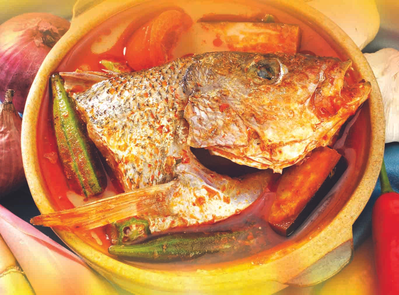 香料豐富的魚頭咖喱俯拍圖 壁紙 — 一鍋用鄉村陶鍋盛載的辣魚咖喱，配有秋葵、番茄和洋蔥，熱氣騰騰。