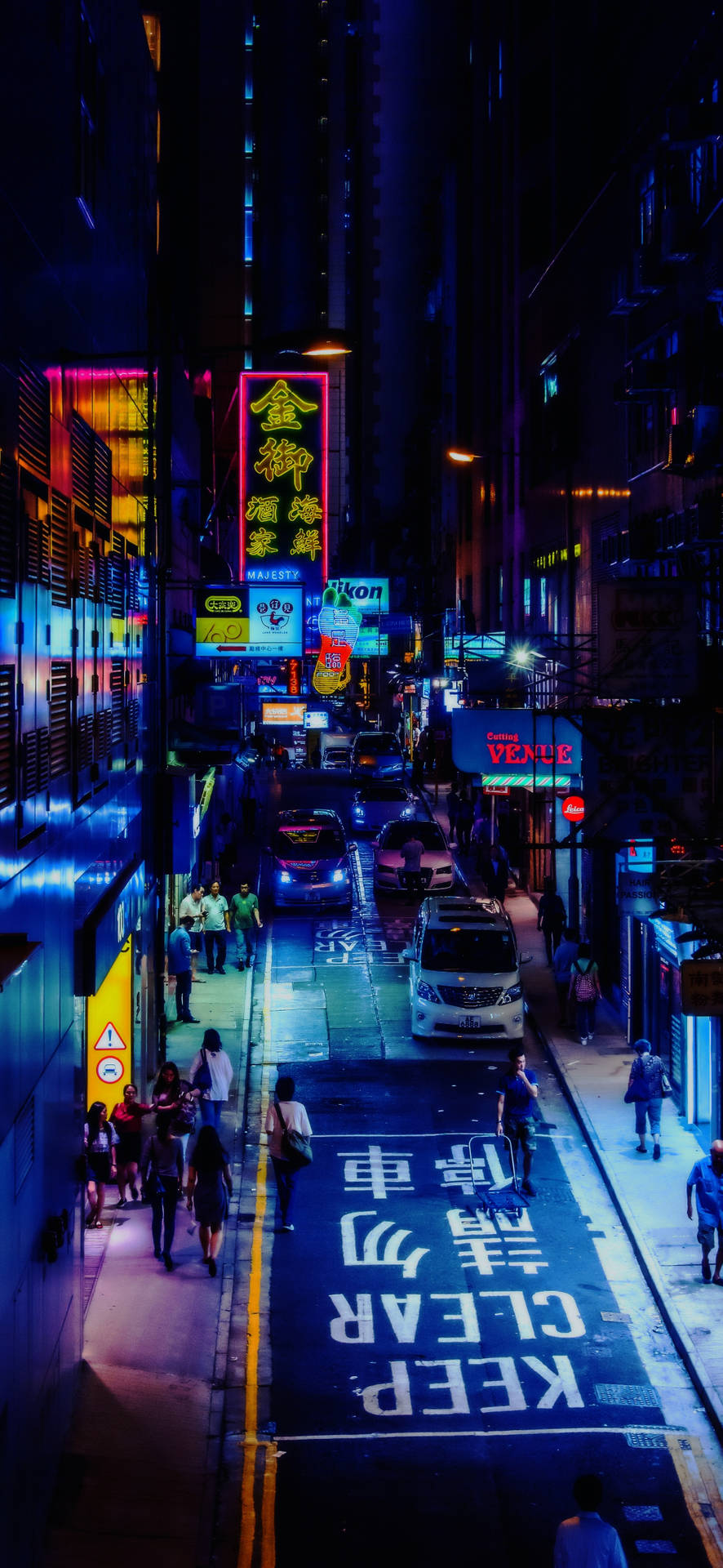 香港中環夜景霓虹街景 壁紙 — 夜晚霓虹燈照亮嘅城市小巷，發光招牌倒映喺濕漉漉嘅路面，行人經過泊咗嘅車。