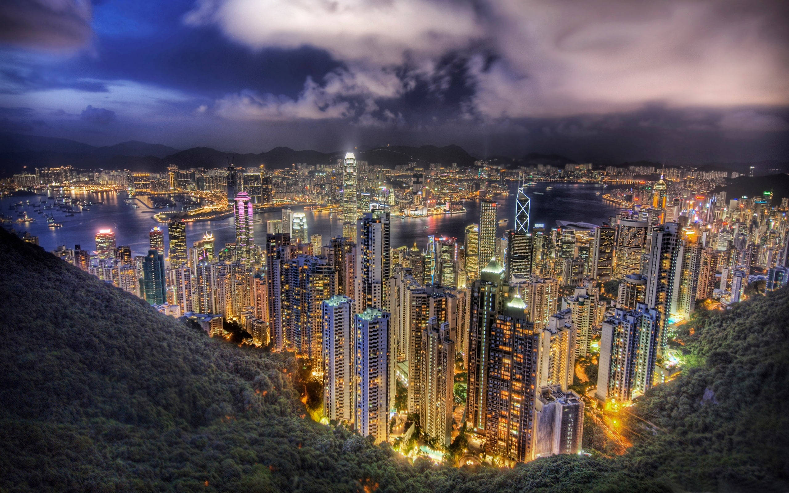 香港城市暮色時分 壁紙 — 香港璀璨的天際線夜景，坐落於鬱鬱蔥蔥的青山與閃爍的港灣之間，令人嘆為觀止的鳥瞰圖。