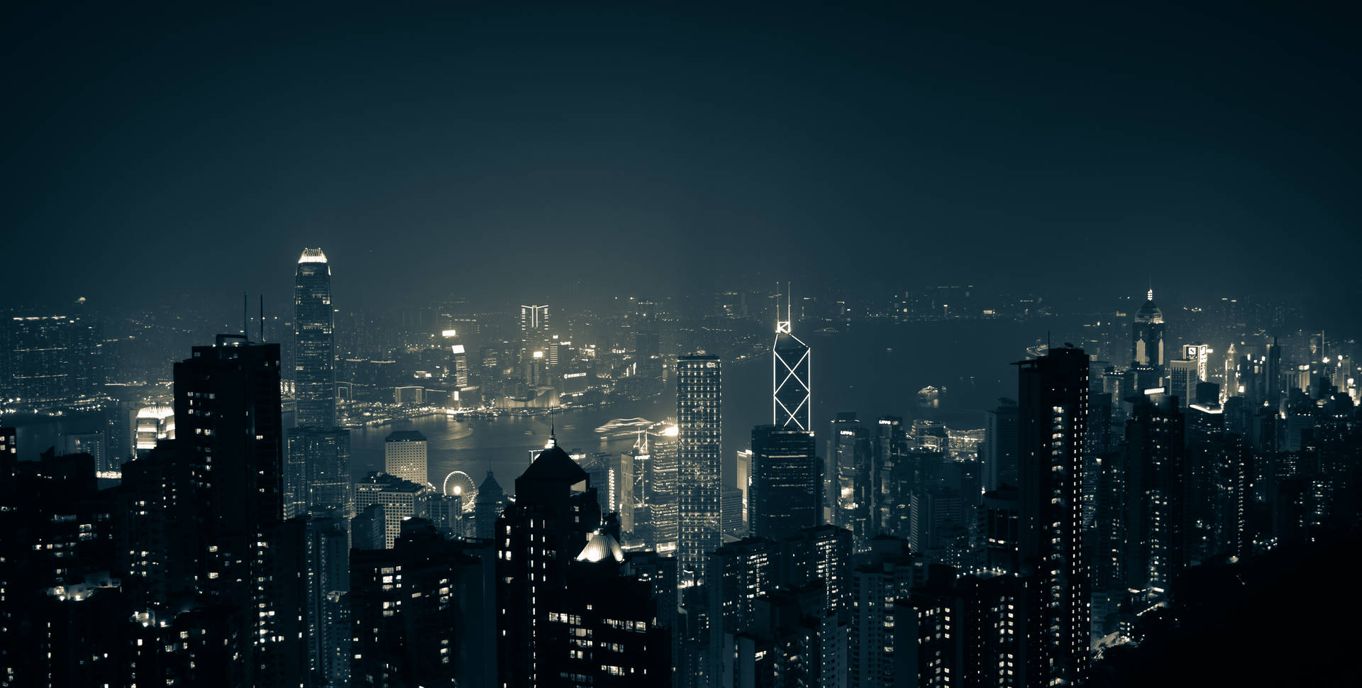 夜間城市景觀，有燈火通明的摩天大樓和黑暗的天空。