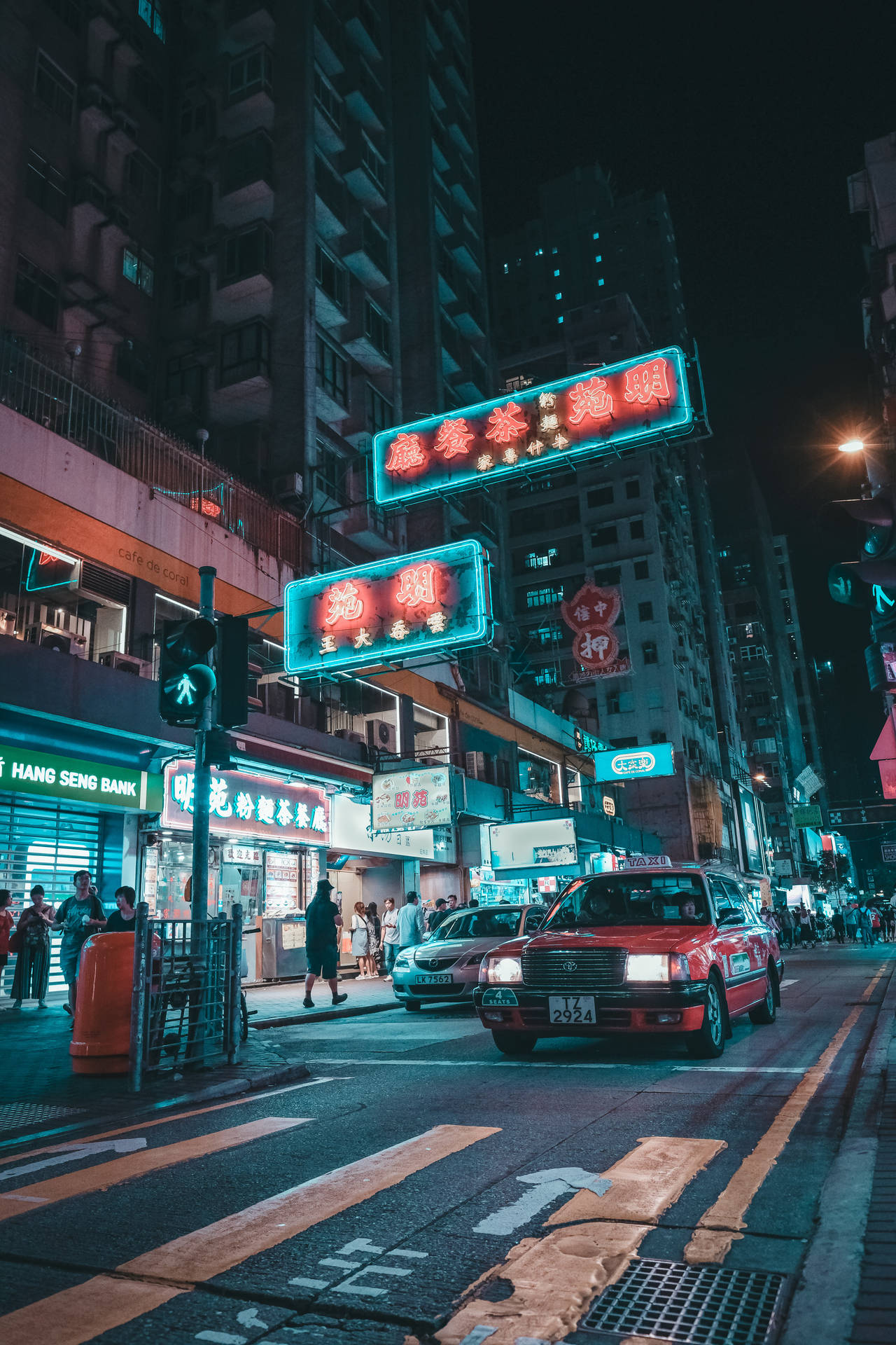 香港街景霓虹燈招牌 壁紙 — 夜晚霓虹燈照亮嘅城市街道，有發光嘅招牌同紅色嘅士喺繁忙嘅交通中穿梭。