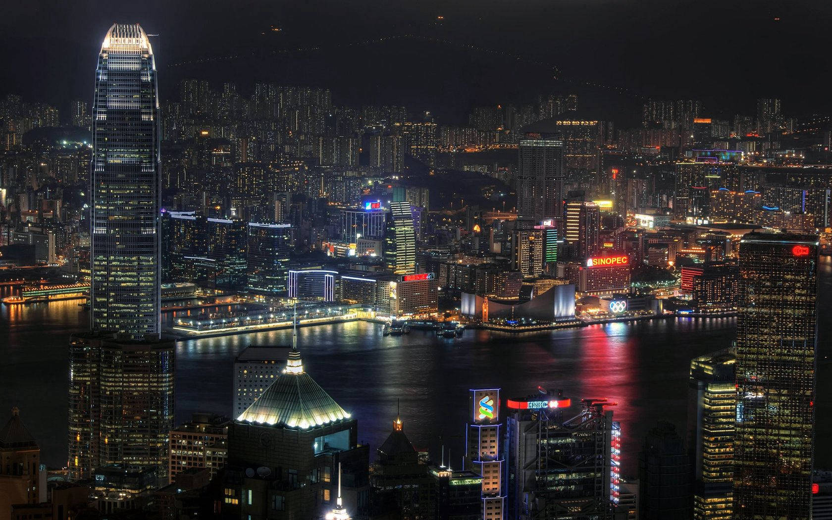 香港夜景，燈火通明的摩天大樓和水面倒影。