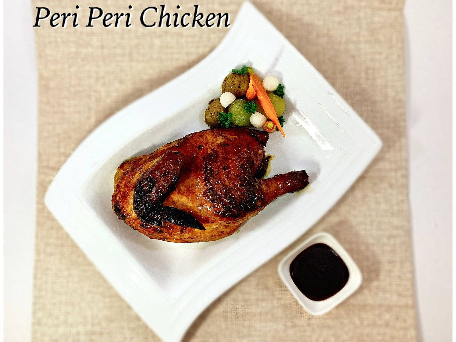 白色碟上的烤 peri peri 雞配蔬菜和蘸醬。