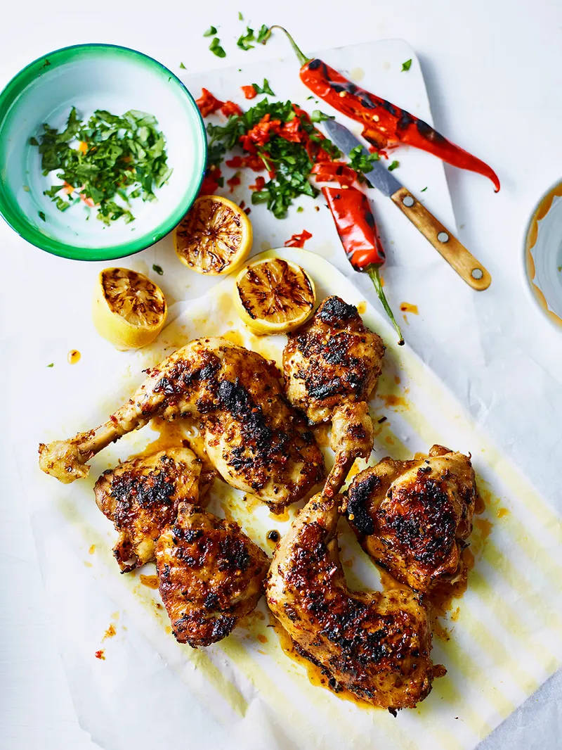 香辣烤雞（Frango Churrasco） 壁紙 — 烤雞腿配烤焦紅辣椒和檸檬半個，放在牛油紙上，配以新鮮香草。